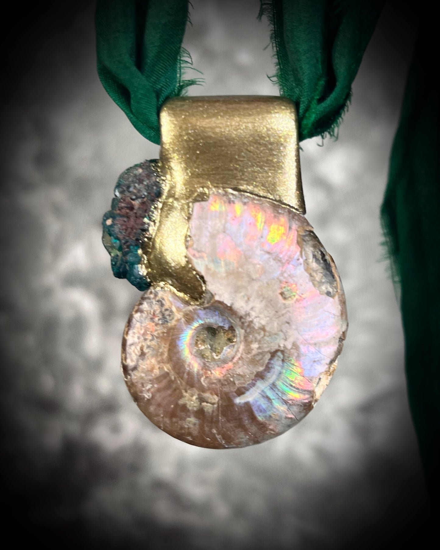 Ammonite fossil pendant with turquoise dioptase gemstones in a gold finish, on an earthy brown leather cord. Fossil healing jewelry for transformation for him or her. 