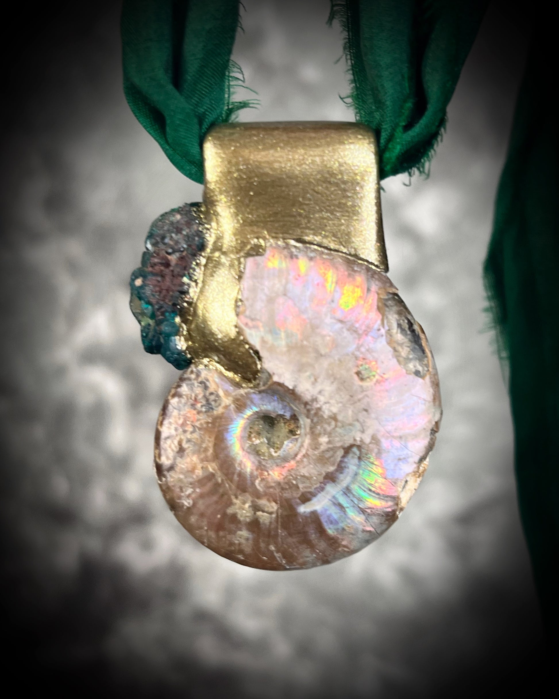 Ammonite fossil pendant with turquoise dioptase gemstones in a gold finish, on an earthy brown leather cord. Fossil healing jewelry for transformation for him or her. 