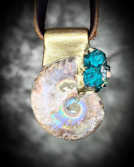 Ammonite fossil pendant with turquoise dioptase gemstones in a gold finish, on an earthy brown leather cord. Fossil healing jewelry for transformation for him or her. 