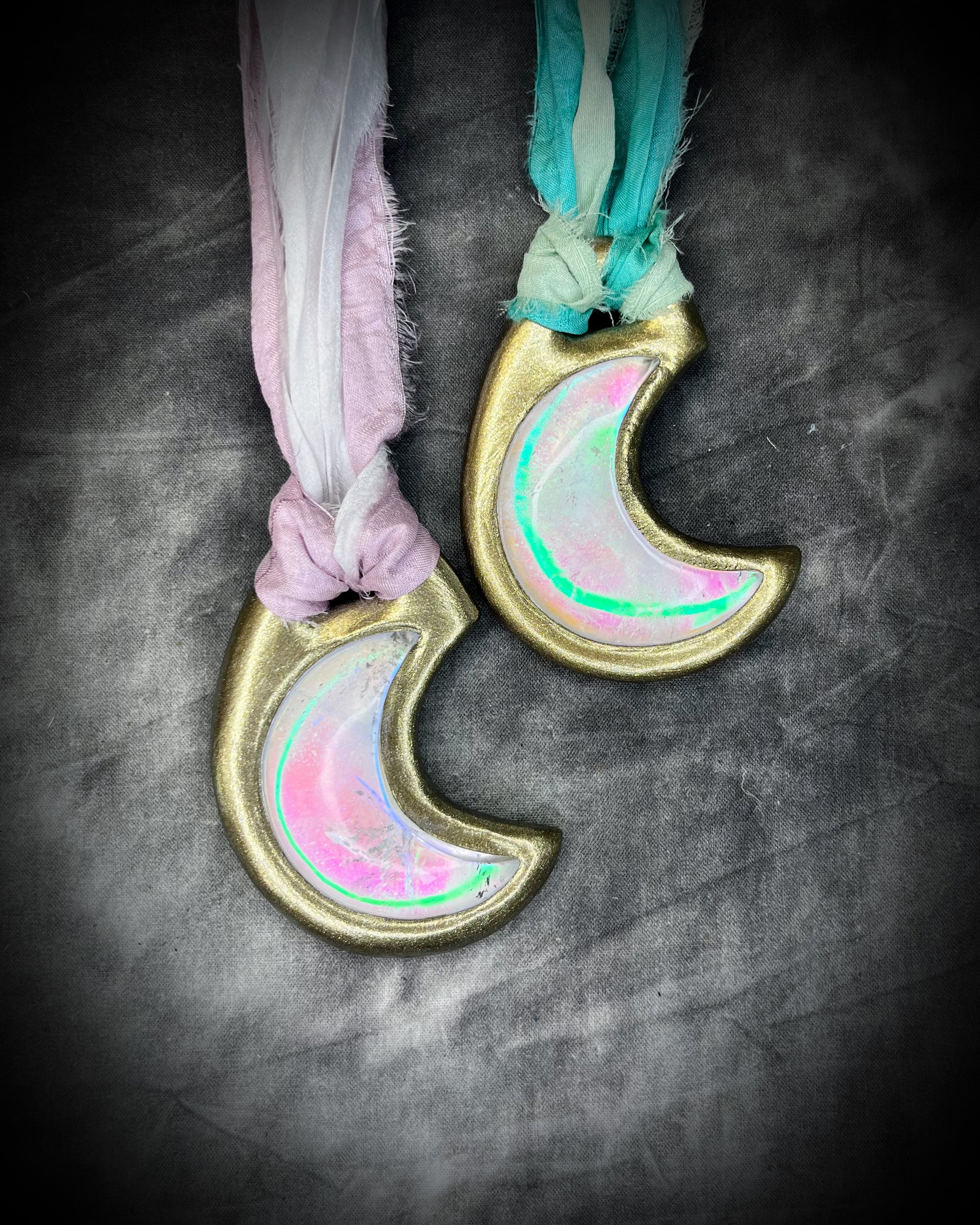 Handmade designer pink and green opalescent quartz gemstone crescent moon pendants in a silver and gold finish.  These crystal healing necklaces are strung from lilac, white, turquoise and mint green recycled silk for the sustainable bride or jewelry collector.