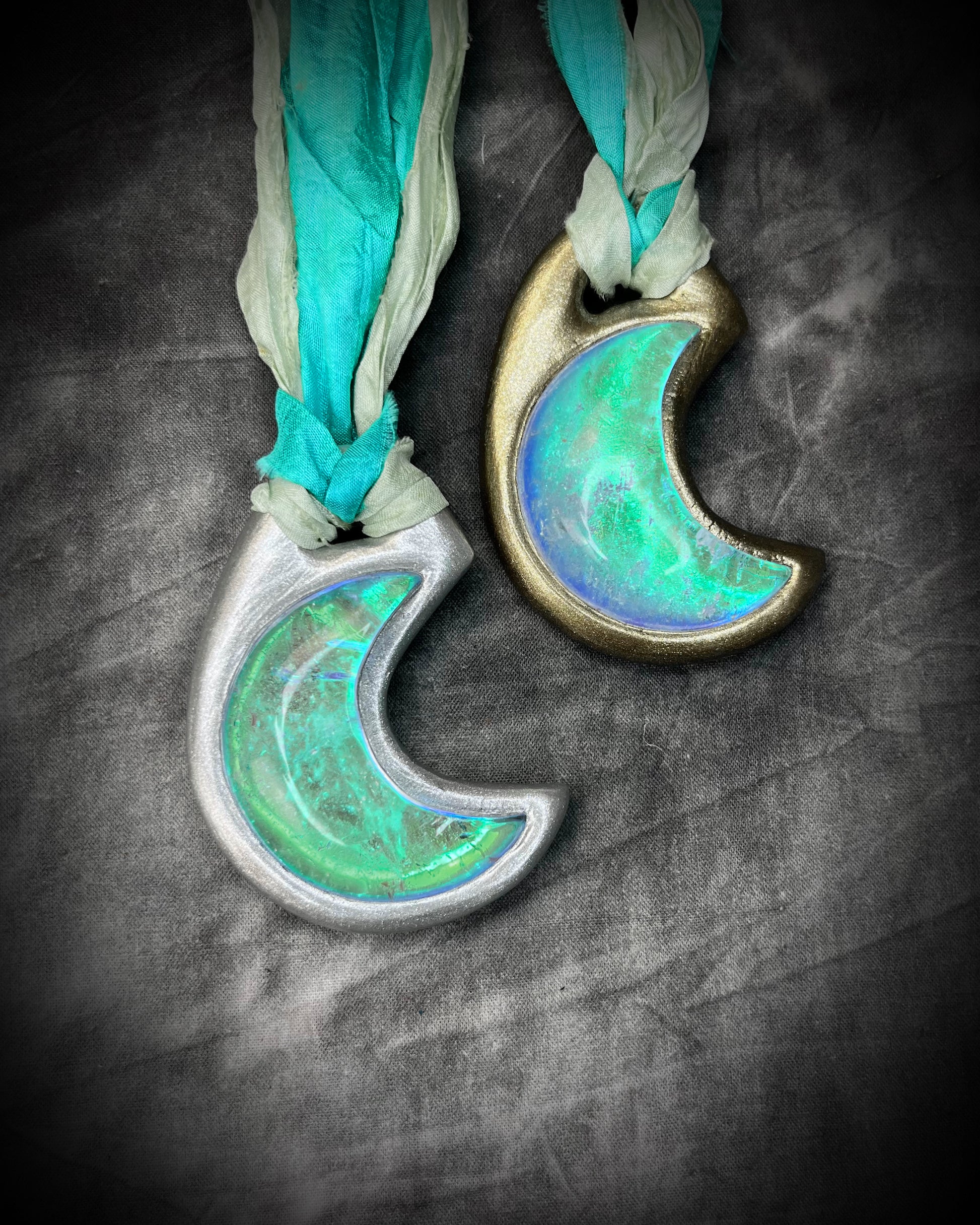 Handmade designer green turquoise opalescent quartz gemstone crescent moon pendants in a silver and gold finish.  This crystal healing necklace is strung from aqua and mint green recycled silk for the eco-friendly jewelry collector.  