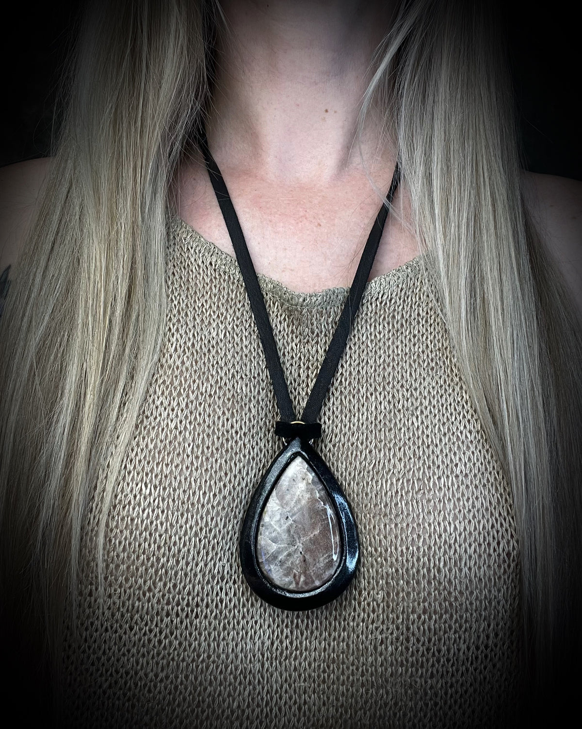 Belomorite sunstone moonstone teardrop pendant with shimmering feldspar color in a sculptural black-finish setting on black leather, handmade by Become Spellbound in Baltimore, Maryland.