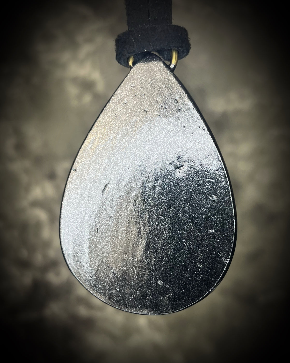 Belomorite sunstone moonstone teardrop pendant with shimmering feldspar color in a sculptural black-finish setting on black leather, handmade by Become Spellbound in Baltimore, Maryland.