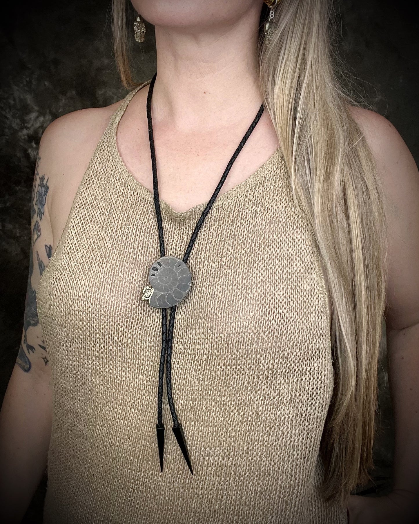 Black ammonite fossil and pyrite bolo tie on black leather with black spike tips, Western gothic statement jewelry with fossil and crystal detail, handmade in Baltimore Maryland.