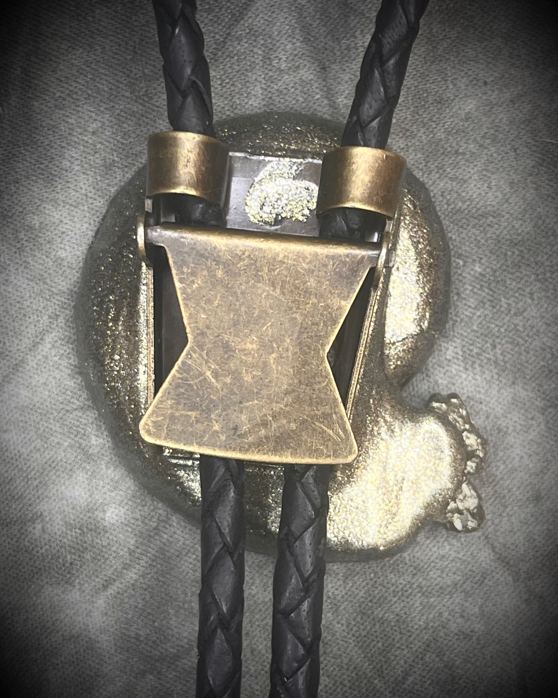 Black ammonite fossil and pyrite bolo tie on black leather with black spike tips, Western gothic statement jewelry with fossil and crystal detail, handmade in Baltimore Maryland. Back view clasp.