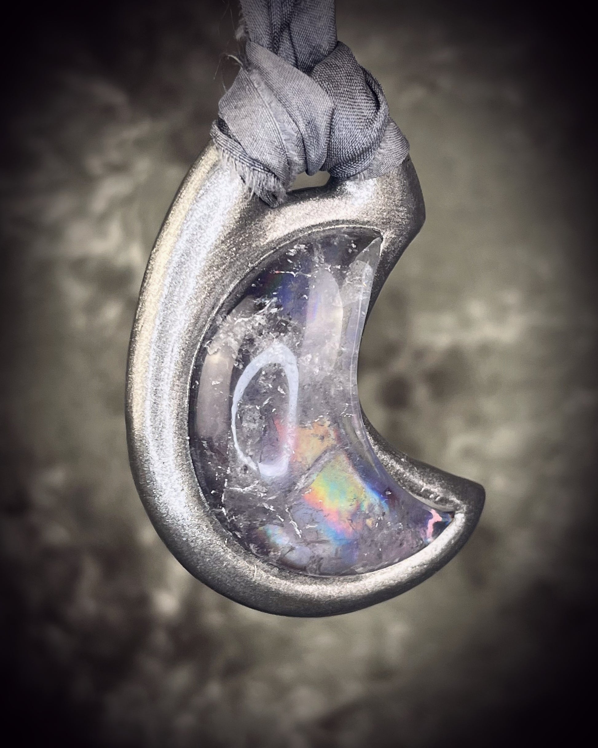 Black rainbow quartz crescent moon talisman on recycled silk with dark iridescent rainbow flashes, handcrafted by Become Spellbound.