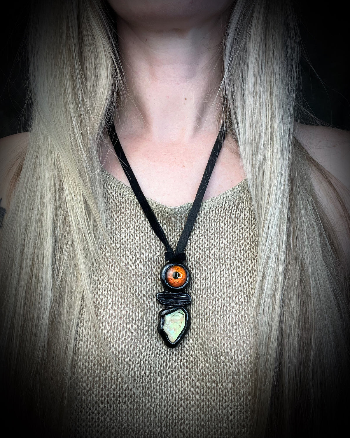 Black tourmaline and Libyan Desert Glass talisman with a man-made eye detail in a sculptural black-finish setting on black leather, handmade by Become Spellbound in Baltimore, Maryland.