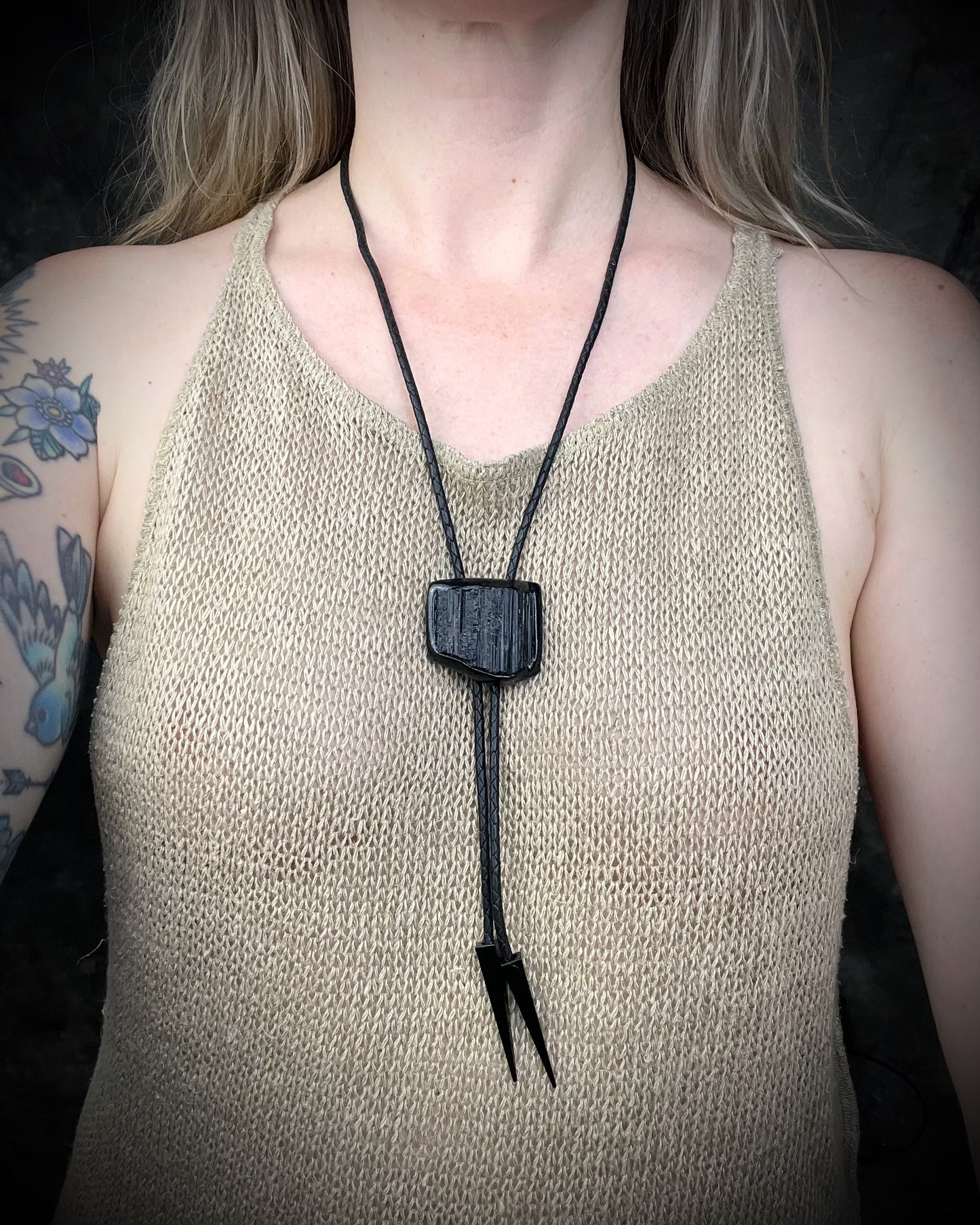 Black tourmaline crystal bolo tie with black spike tips on black leather, gothic statement jewelry for protection and grounding, handmade in Baltimore Maryland. Modeled here to show size. 
