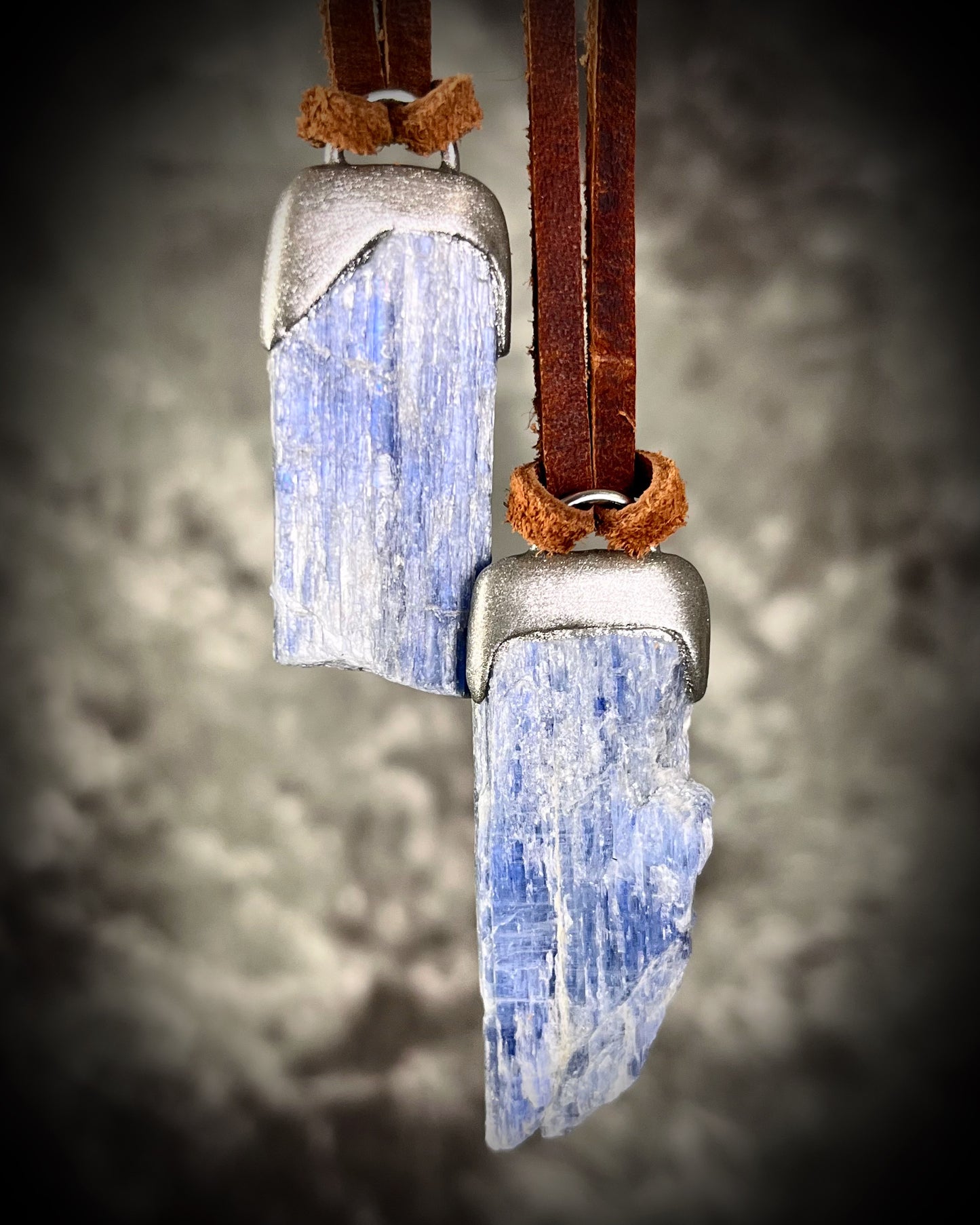 Blue Kyanite crystal pandant in silver finish, hung from organic brown leather for earthy elegance. Raw gemstone talismans for truth, communication and wisdom make perfect holiday gifts!