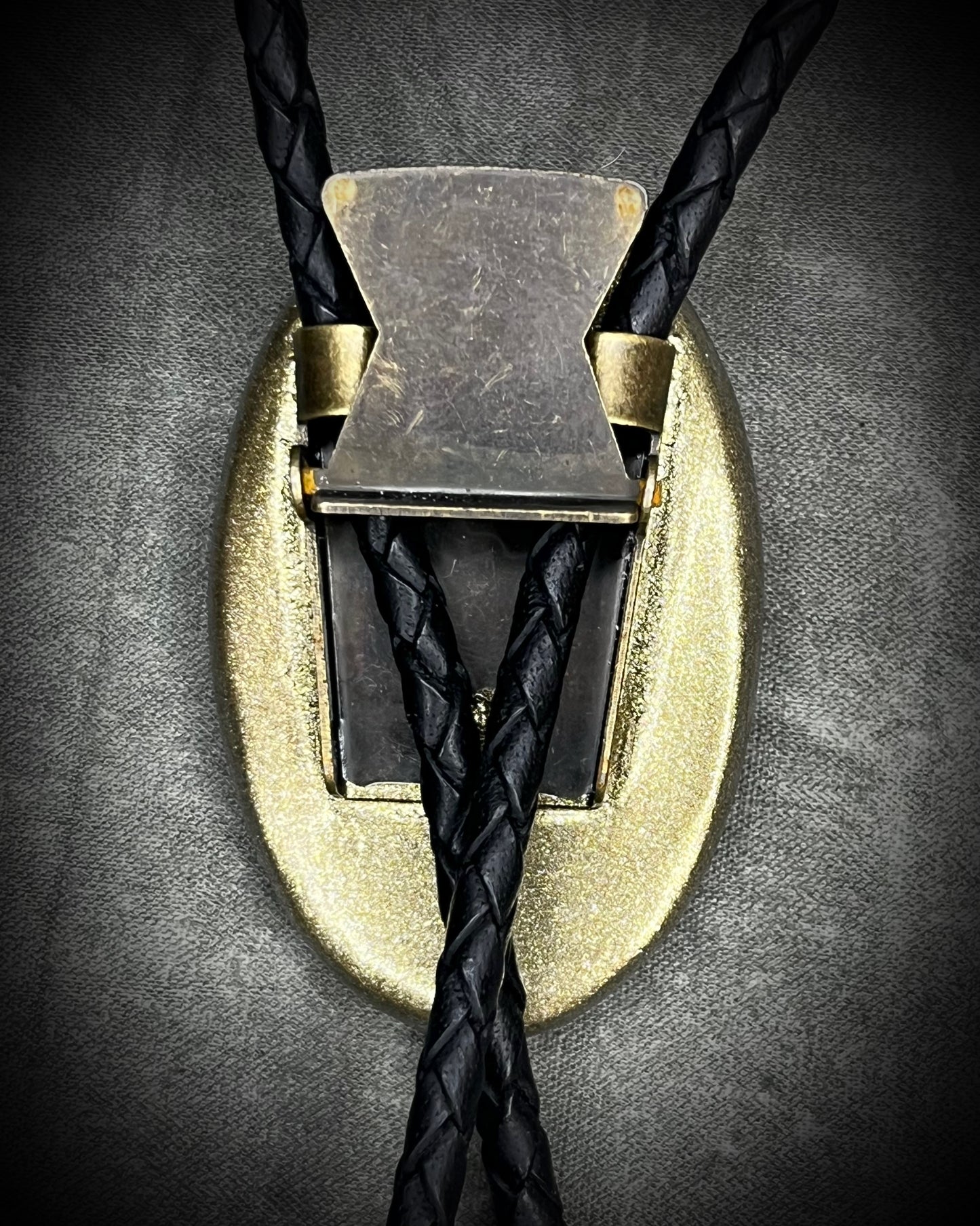 Blue flash labradorite bolo tie with black leather cord, gold finish, and antique gold spike bolo tips. Handmade by Become Spellbound.