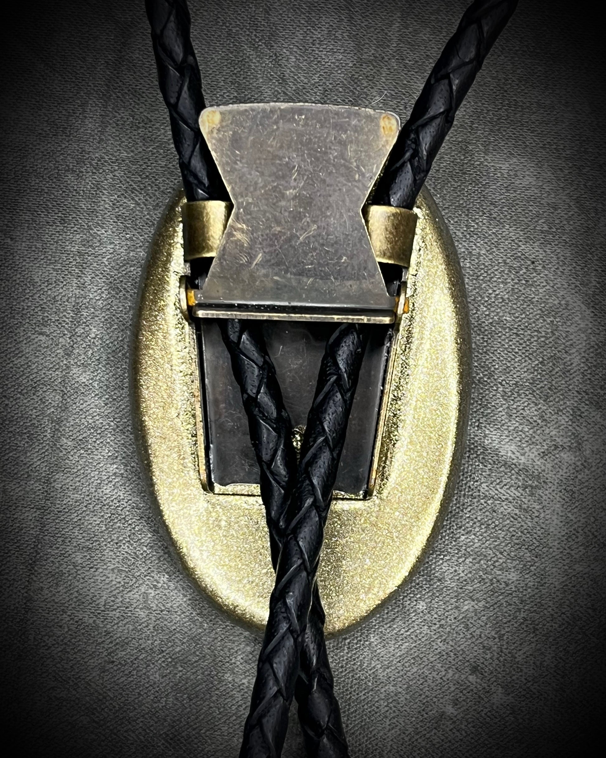 Blue flash labradorite bolo tie with black leather cord, gold finish, and antique gold spike bolo tips. Handmade by Become Spellbound.