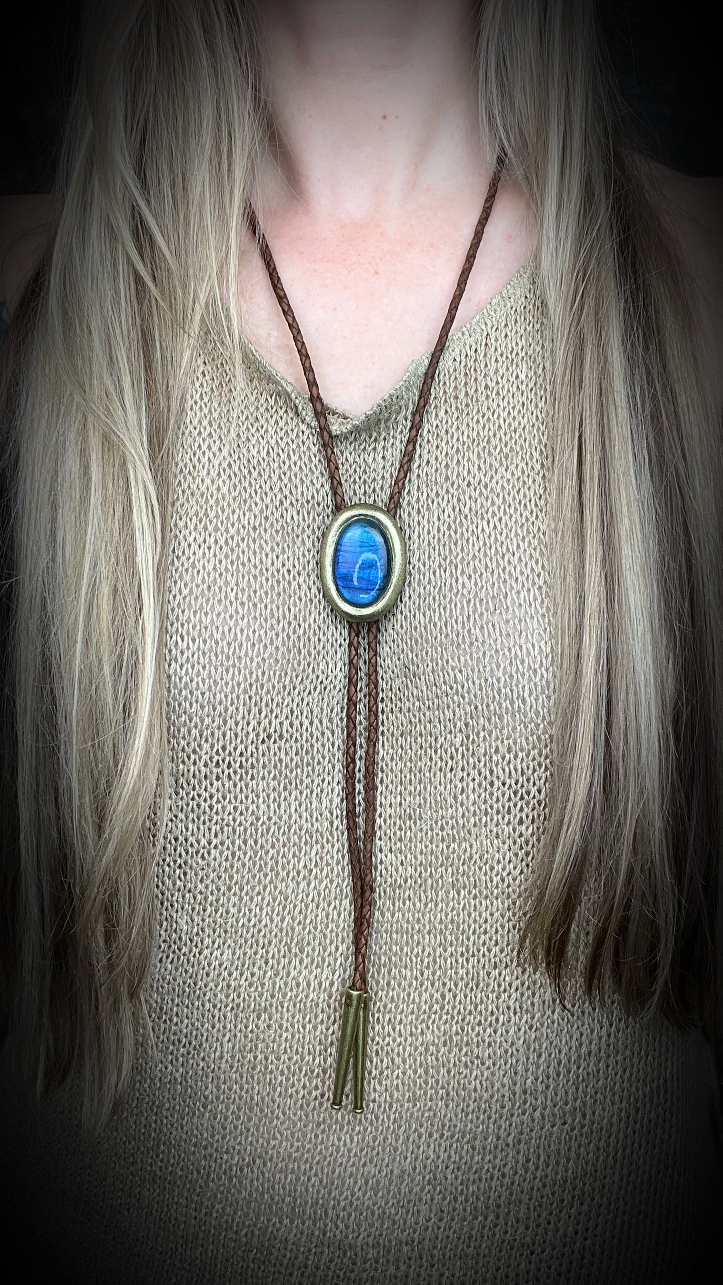 Blue flash labradorite bolo tie with brown leather cord, gold finish, and decorative sunburst bolo tips. Handmade by Become Spellbound.