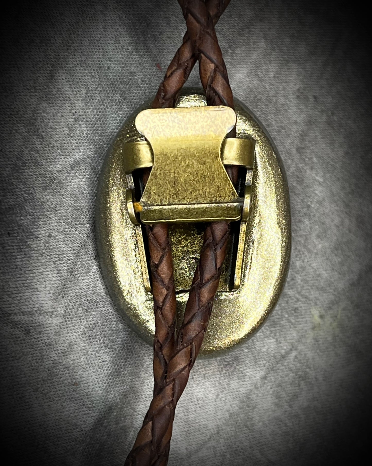 Blue flash labradorite bolo tie with brown leather cord, gold finish, and decorative sunburst bolo tips. Handmade by Become Spellbound.
