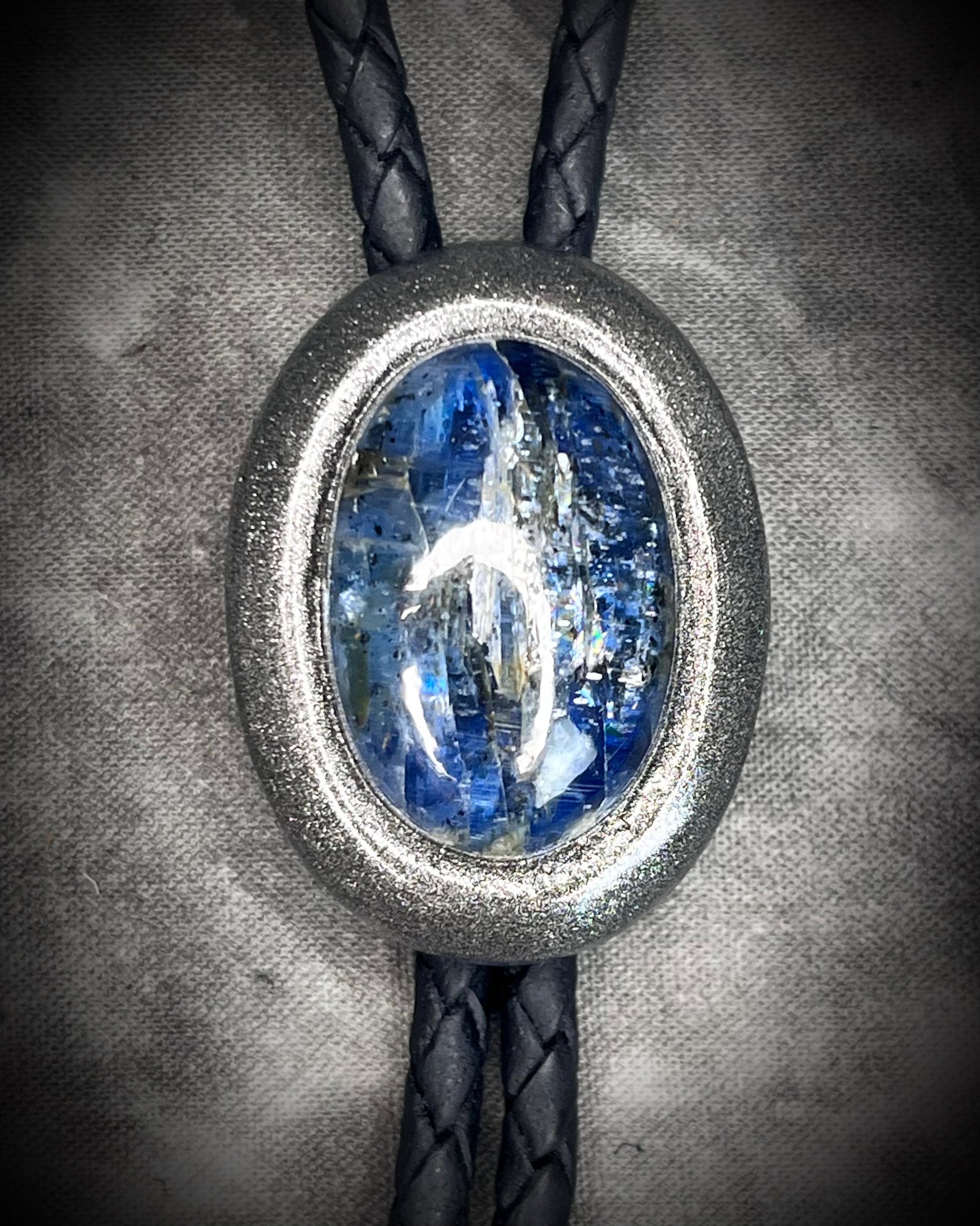 Blue kyanite handmade bolo tie for him or her, gunmetal silver finish on black leather.
