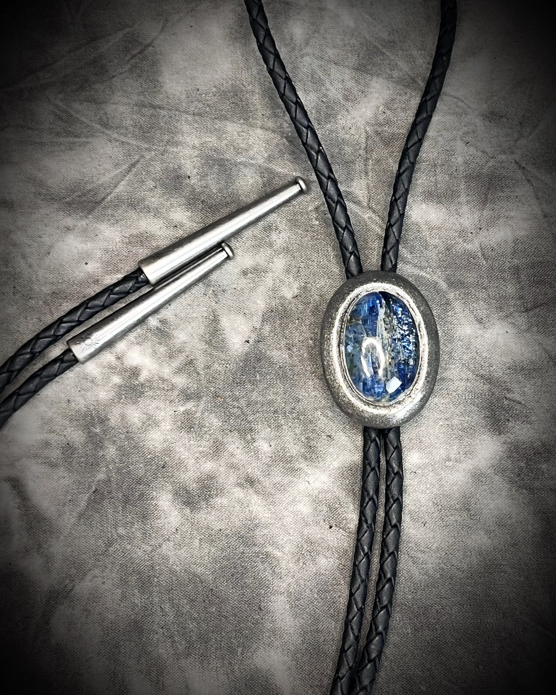 Blue kyanite handmade bolo tie for him or her, gunmetal silver finish on black leather.