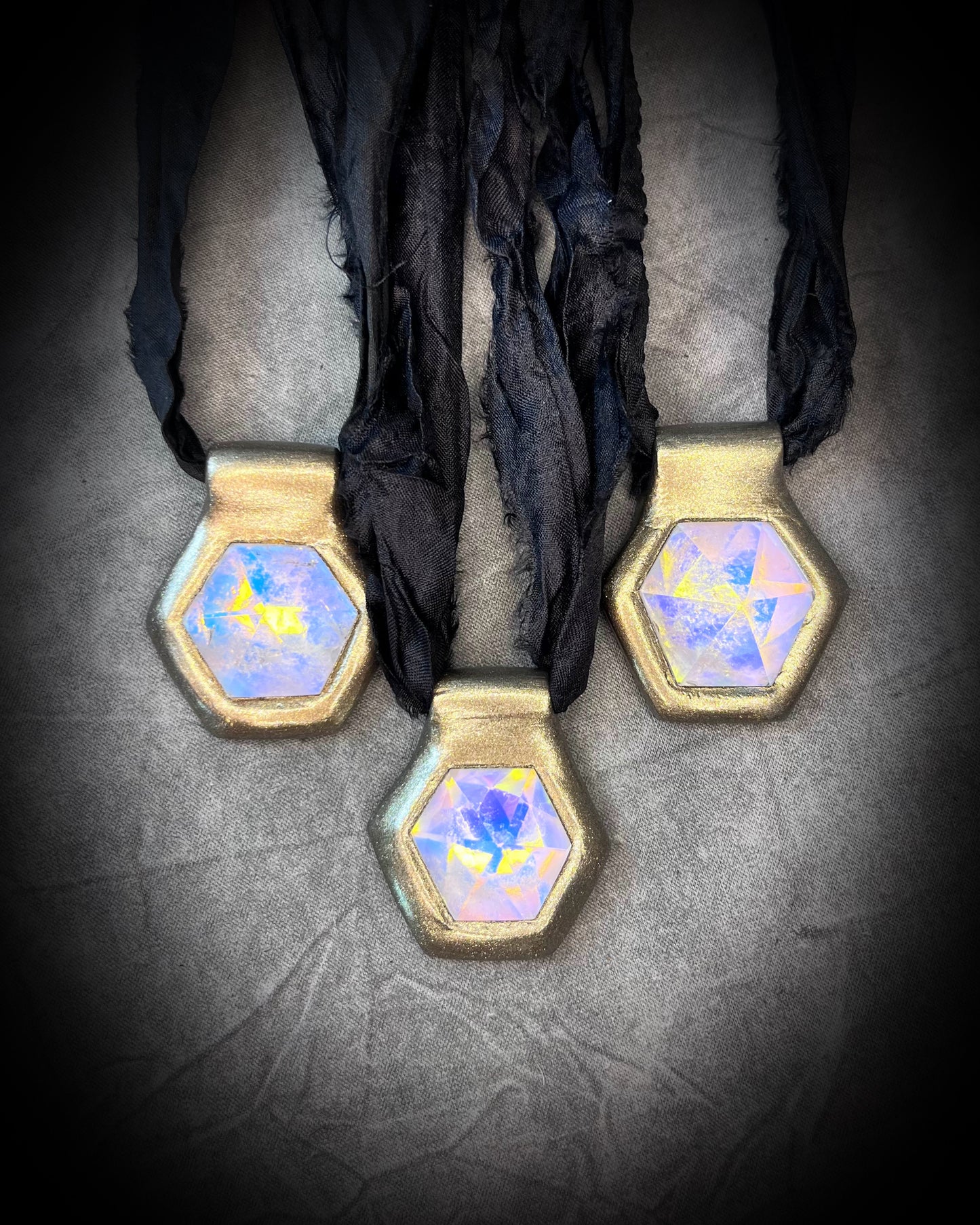 Handmade designer clear opalescent quartz gemstone pendants in a gold finish.  These crystal healing pyramid hexagon necklaces are strung from black recycled silk for the sustainable and eco-friendly jewelry lover, boho babe or modern mystic. 