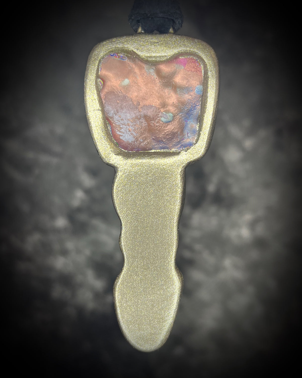 One-of-a-kind Cadillac Ranch Fordite talisman with hand-cut Fordite cabochon, black tourmaline, ruby, and Libyan Desert Glass in a gold-finish setting on black leather, handmade by Become Spellbound in Baltimore, Maryland.