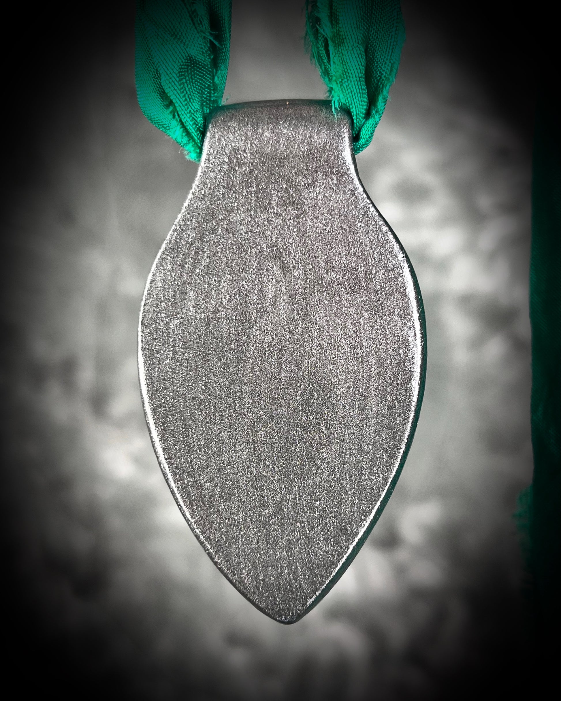 Chlorite Included Quartz necklace in a dark silver gunmetal finish on emerald green recycled silk, glowing with natural green mosslike crystal inclusions.