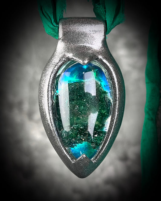 Chlorite Included Quartz necklace in a dark silver gunmetal finish on emerald green recycled silk, glowing with natural green mosslike crystal inclusions.