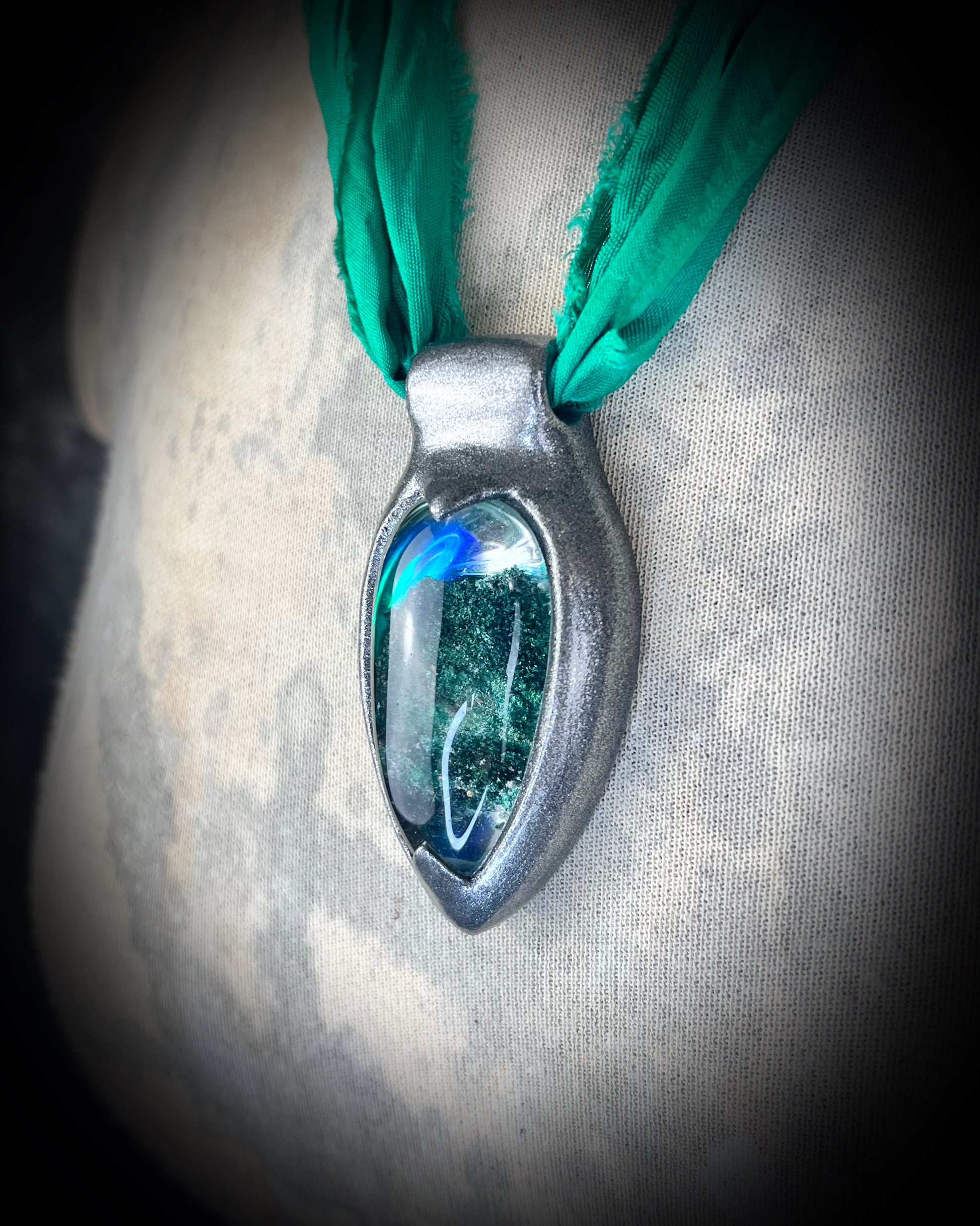 Chlorite Included Quartz necklace in a dark silver gunmetal finish on emerald green recycled silk, glowing with natural green mosslike crystal inclusions.
