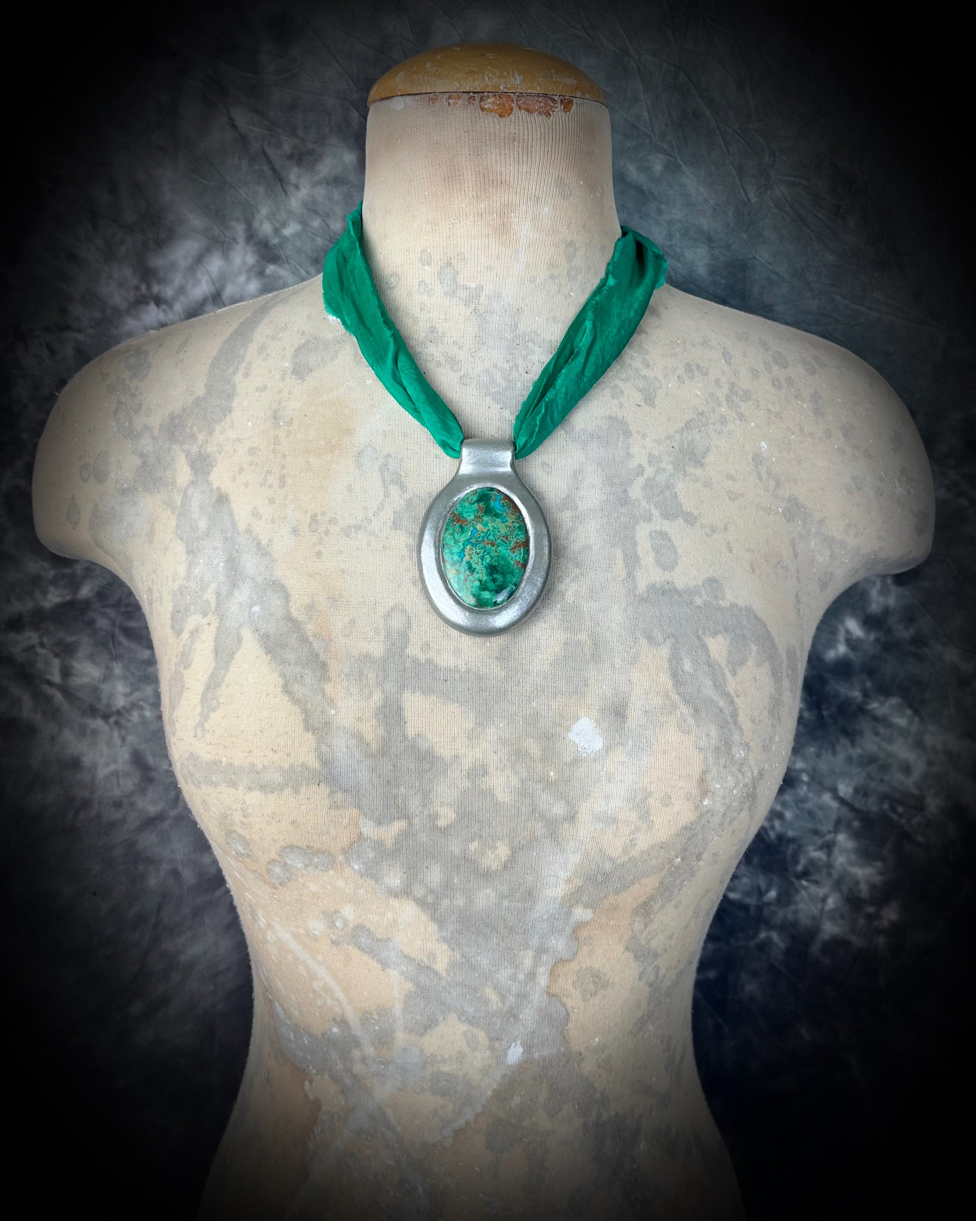 Chrysocolla crystal necklace on emerald green recycled silk, displayed in natural light on a mannequin.