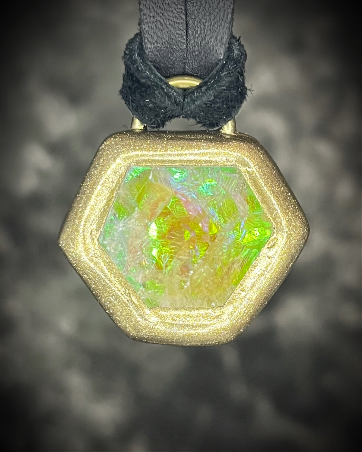 Citrine quartz pyramid crystal with a mystical green glow in a sculptural gold-finish talisman setting on black leather, handmade by Become Spellbound in Baltimore, Maryland.