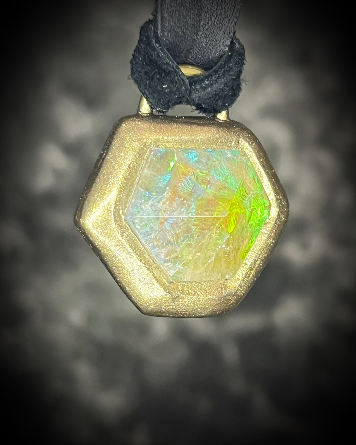 Citrine quartz pyramid crystal with a mystical green glow in a sculptural gold-finish talisman setting on black leather, handmade by Become Spellbound in Baltimore, Maryland.