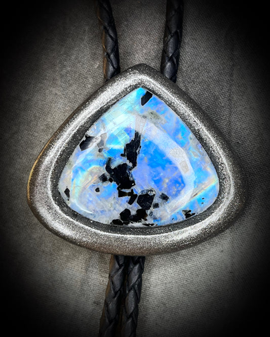 Close-up of gunmetal silver bolo setting with glowing rainbow flash.