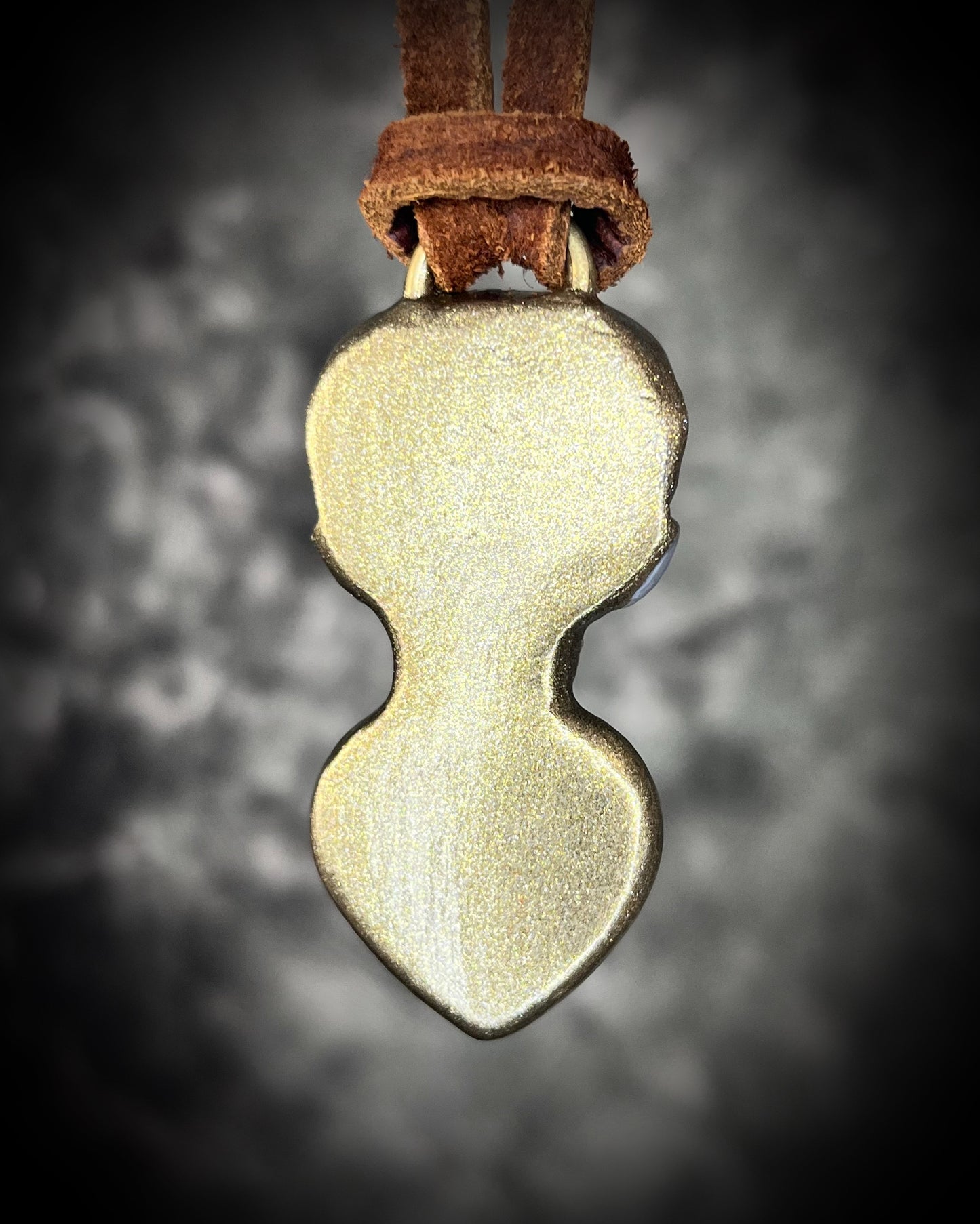 Close-up of pearl white sculpted skull and glowing Carnelian heart framed in gold — handmade gothic bohemian jewelry.