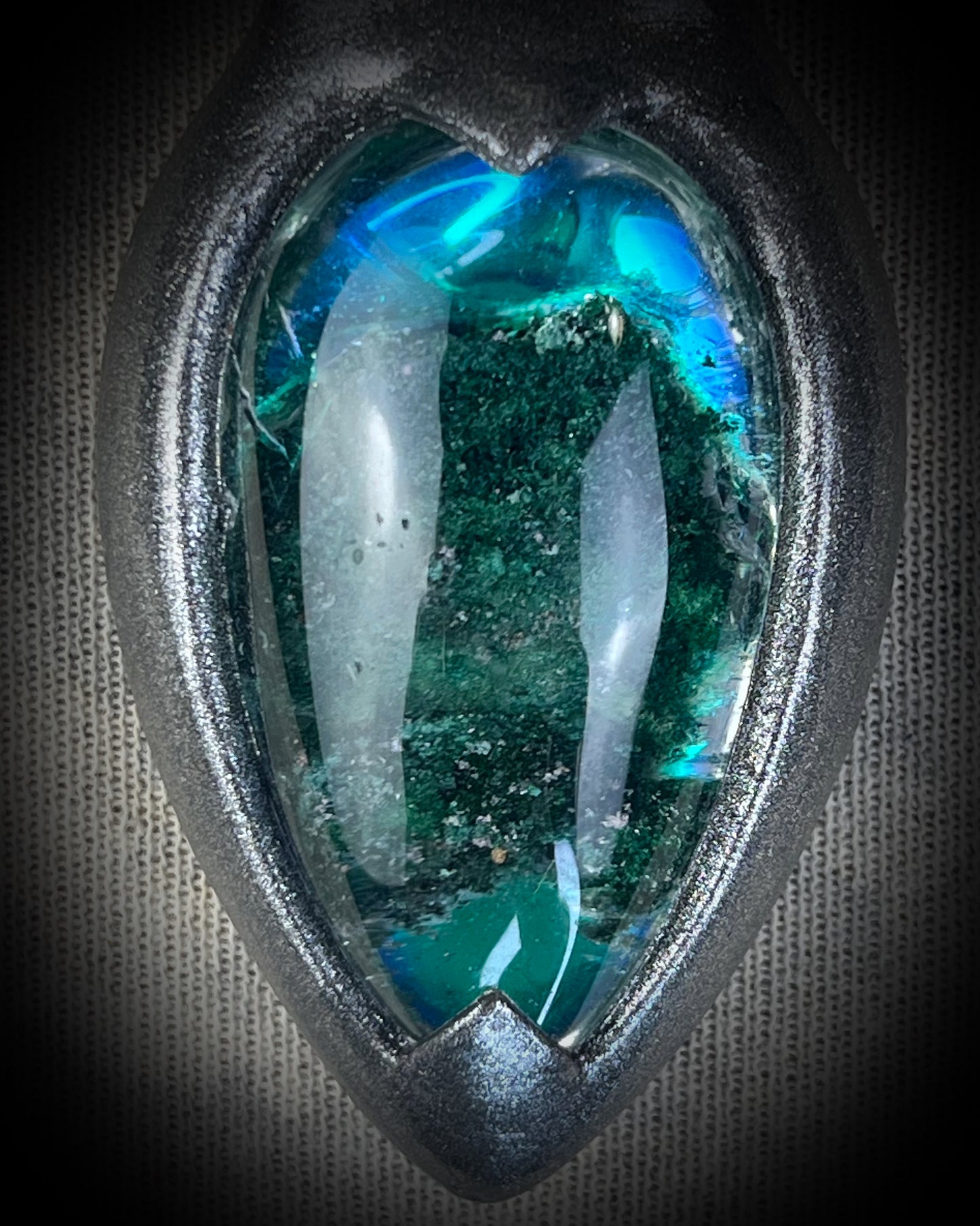 Chlorite Included Quartz necklace in a dark silver gunmetal finish on emerald green recycled silk, glowing with natural green mosslike crystal inclusions.