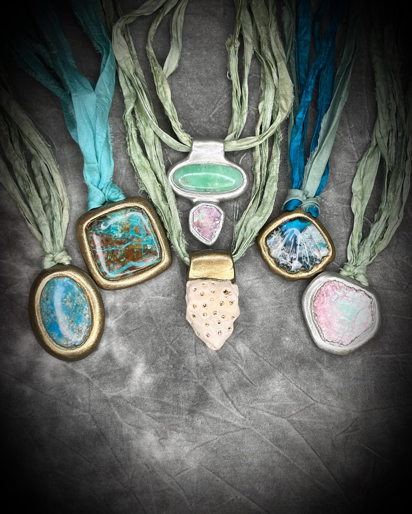 Collection of necklaces with various ocean inspired crystal and fossil pendants all hung from shades of aqua and sea green recycled silk. Summer beach jewelry gift for her. 