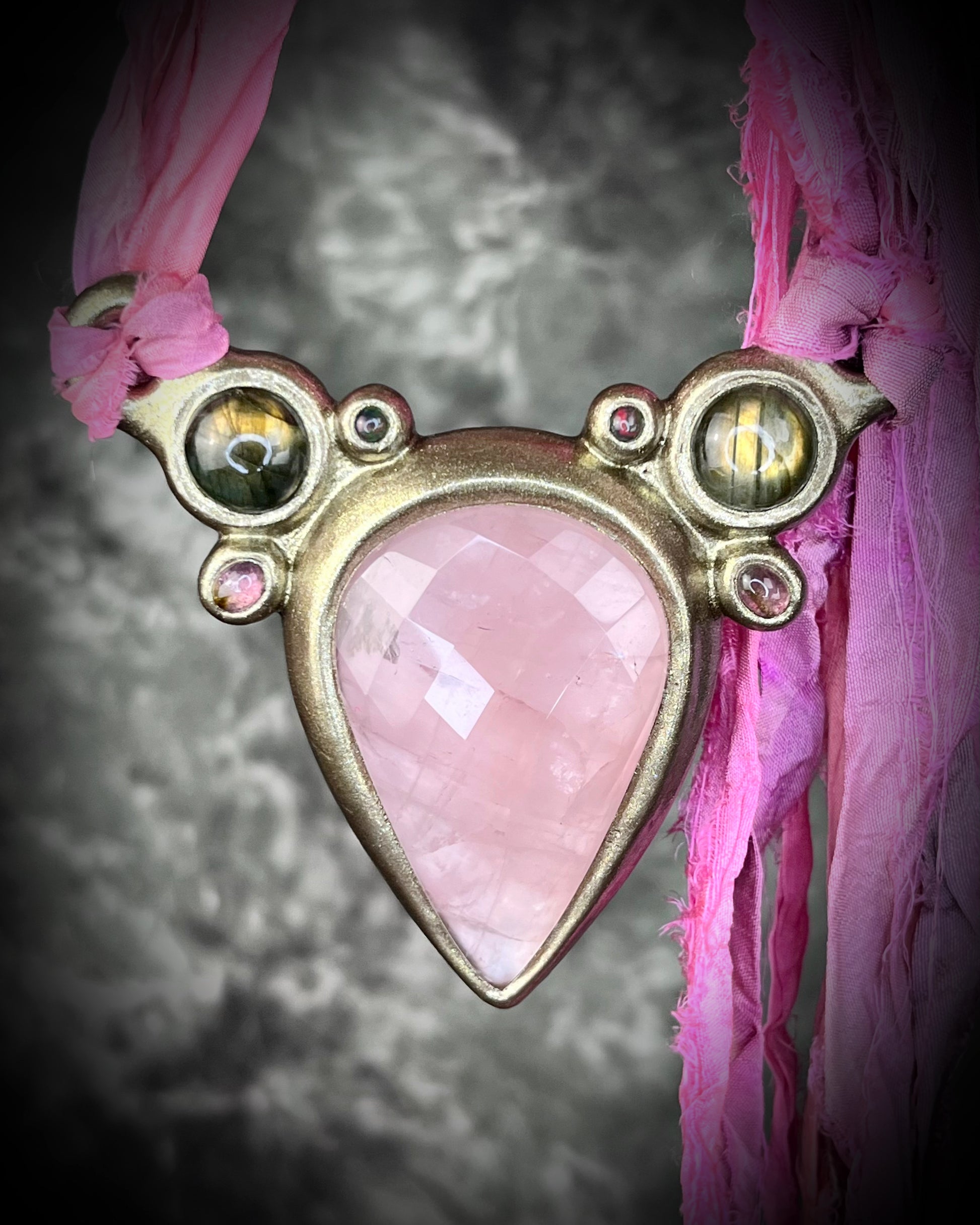 Statement Maximalist goddess collar featuring large faceted Rose Quartz Crystal, two glowing labradorite gemstones, pink tourmaline and black opals.  Bold jewelry for a big impact!