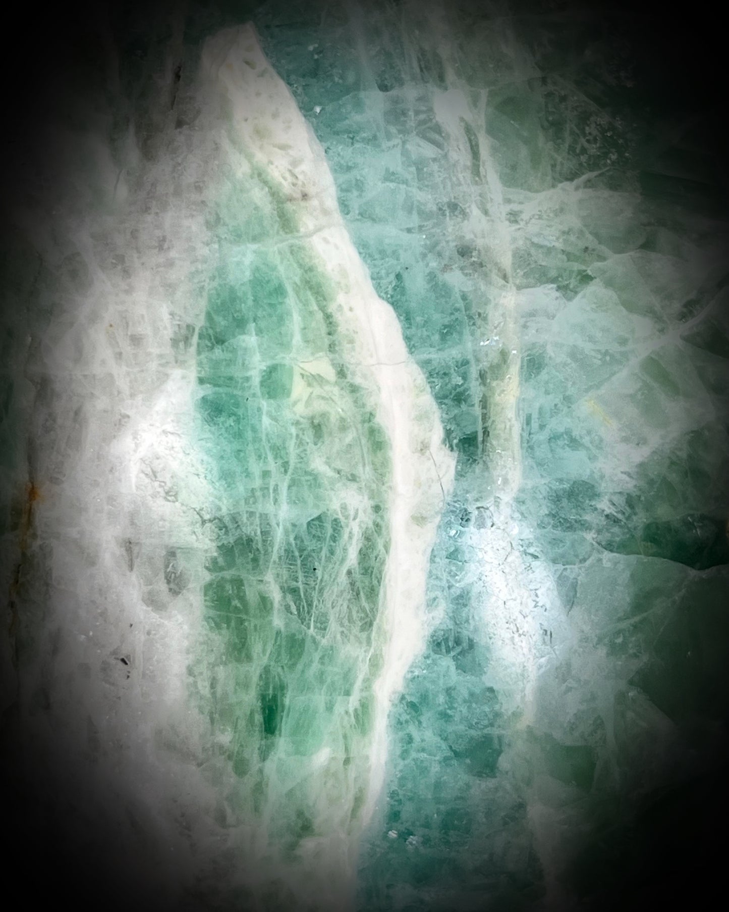 Detail shot of Large 5-inch green fluorite crystal skull with layered green bands and polished carved features.