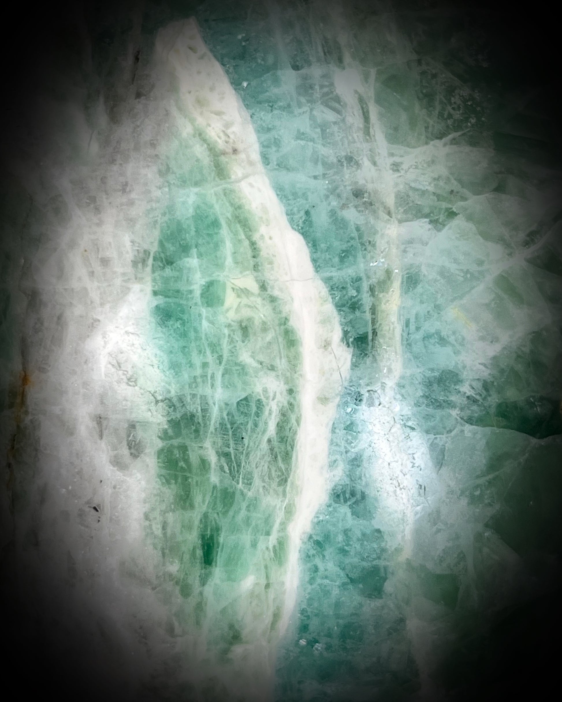 Detail shot of Large 5-inch green fluorite crystal skull with layered green bands and polished carved features.