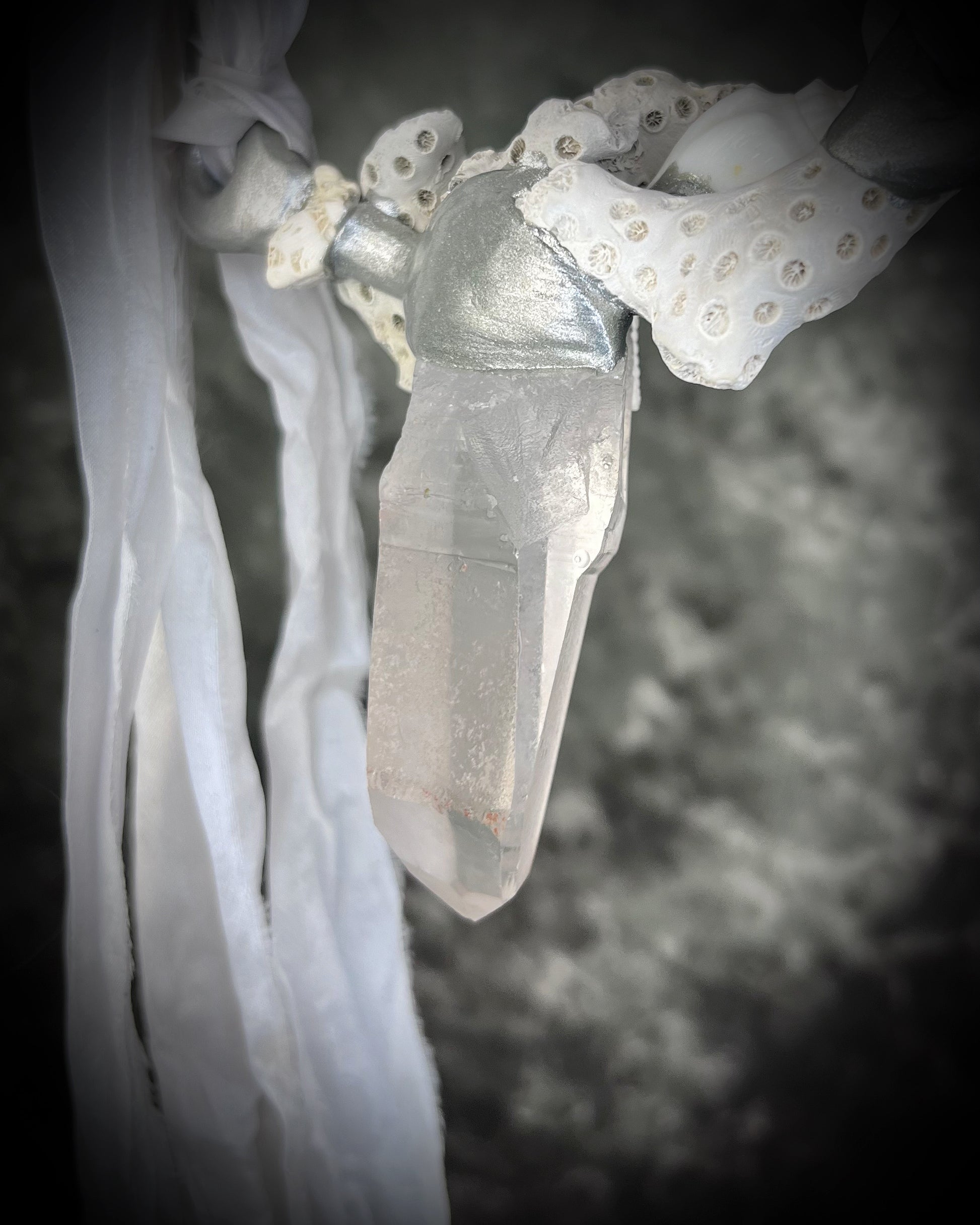 Rear view of handcrafted woman designer bridal or beach bride necklace featuring quartz crystal, white fossilized coral, starfish, seashell and is strung from recycled white silk for an eco-friendly summer beach wedding elegance.  