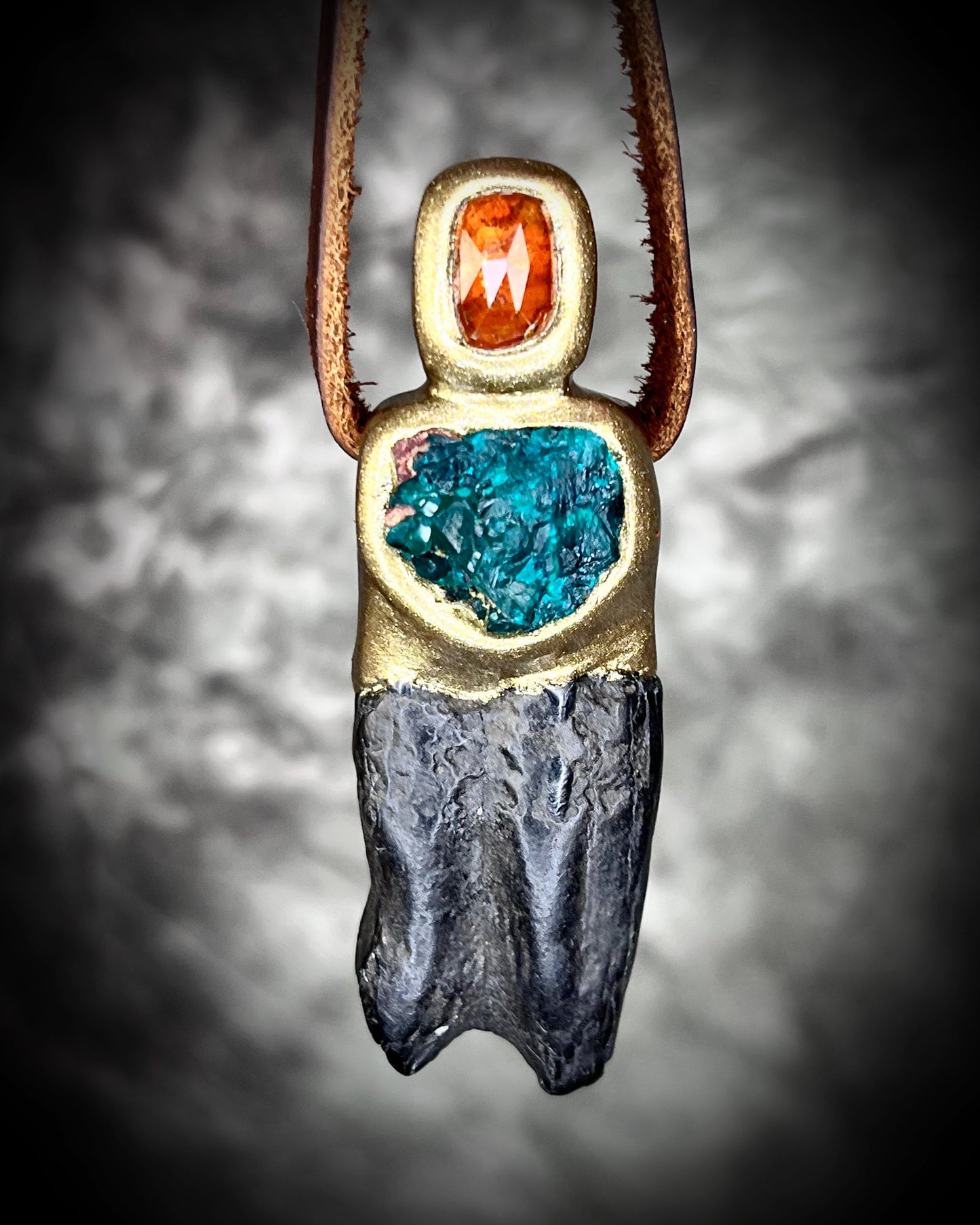 Close-up of gold-tone Equus horse tooth fossil pendant adorned with orange kyanite and green dioptase crystals — mystical handcrafted fossil and crystal necklace