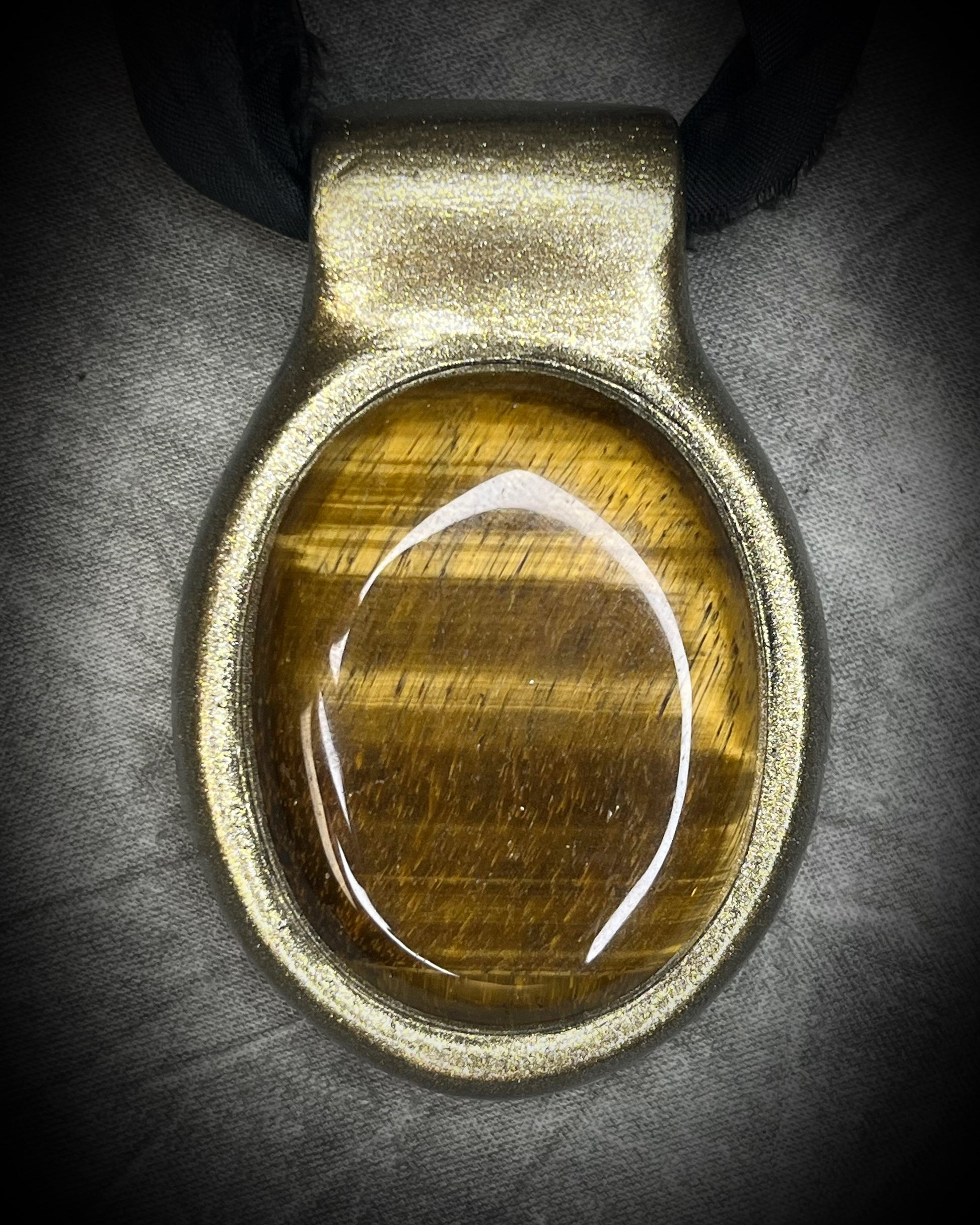 Extra large tiger's eye crystal talisman with golden-brown natural banding, gold finish, and black recycled silk ties, handmade by Become Spellbound in Baltimore, Maryland.