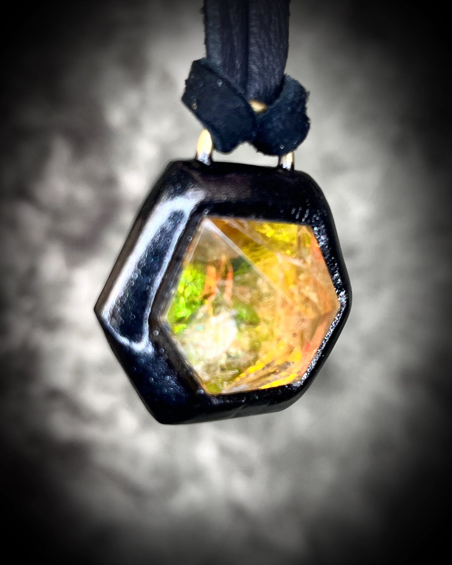 Fiery citrine hexagon crystal pendant with red, green, and orange opalescent flash in black finish on black leather cord — handcrafted statement talisman