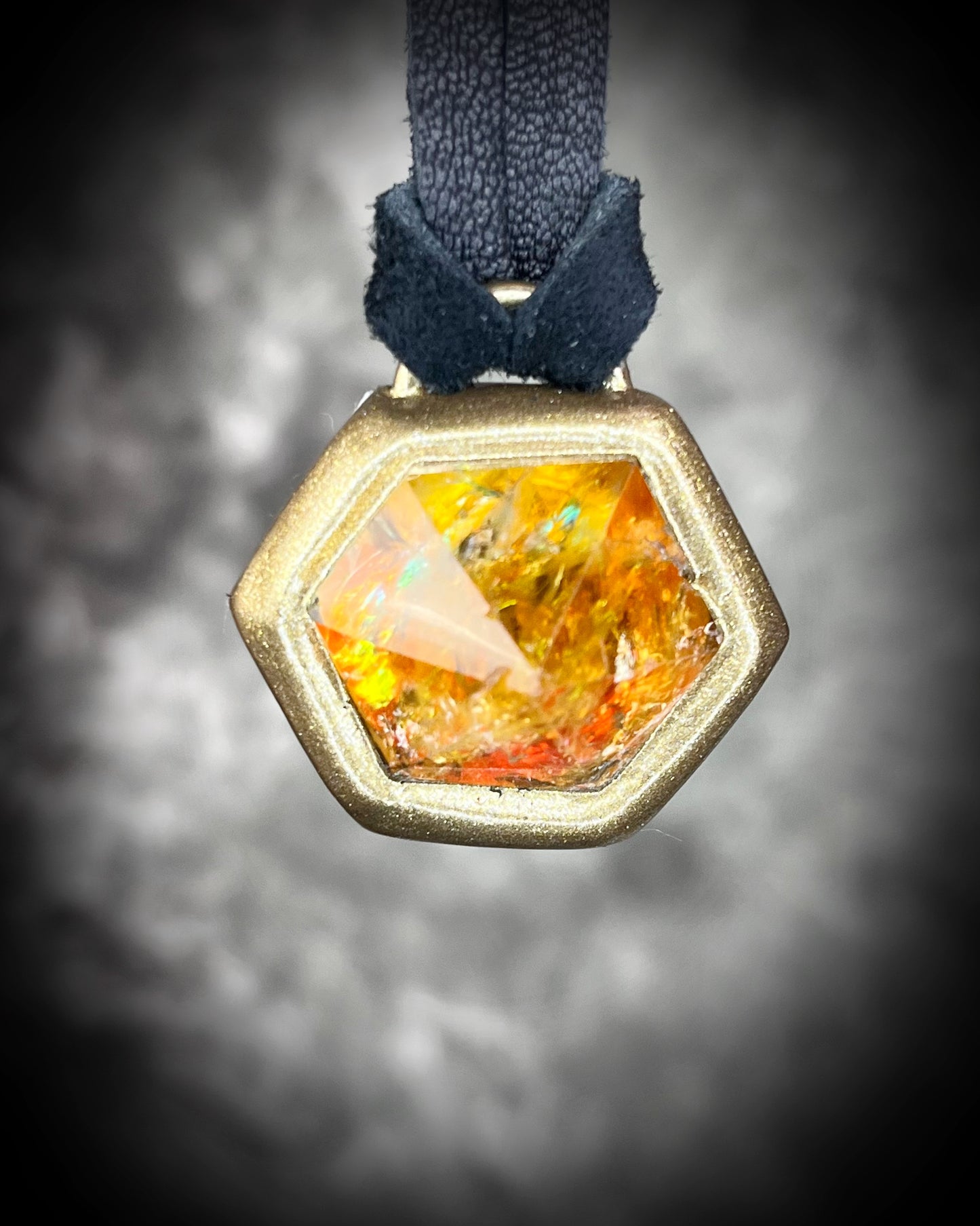 Fiery citrine hexagon crystal pendant with red, green, and orange opalescent flash in black finish on black leather cord — handcrafted statement talisman