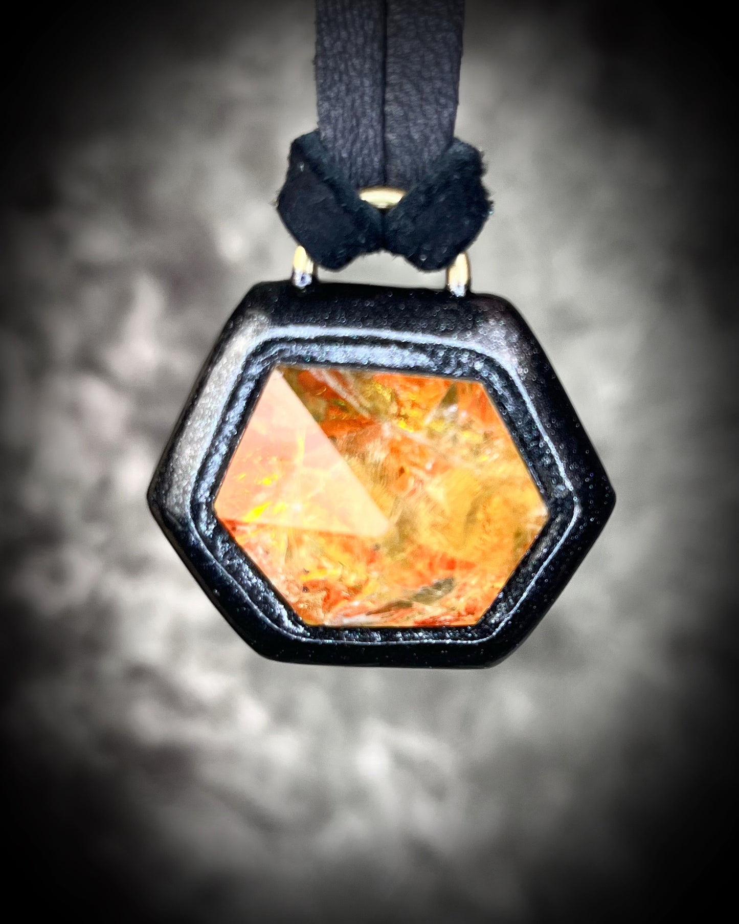 Fiery citrine hexagon crystal pendant with red, green, and orange opalescent flash in black finish on black leather cord — handcrafted statement talisman