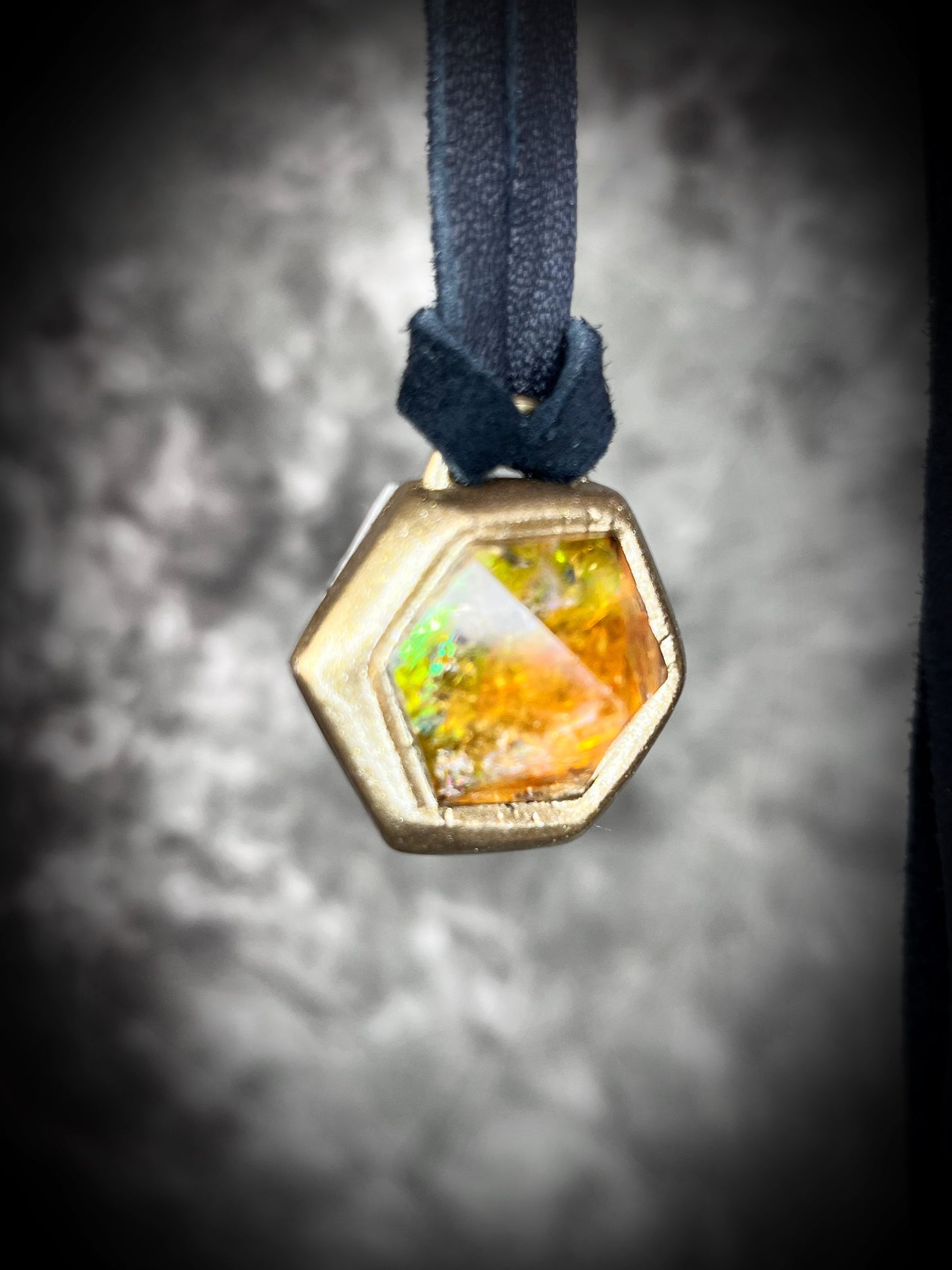 Fiery citrine hexagon crystal pendant with red, green, and orange opalescent flash in gold finish on black leather cord — handcrafted statement talisman