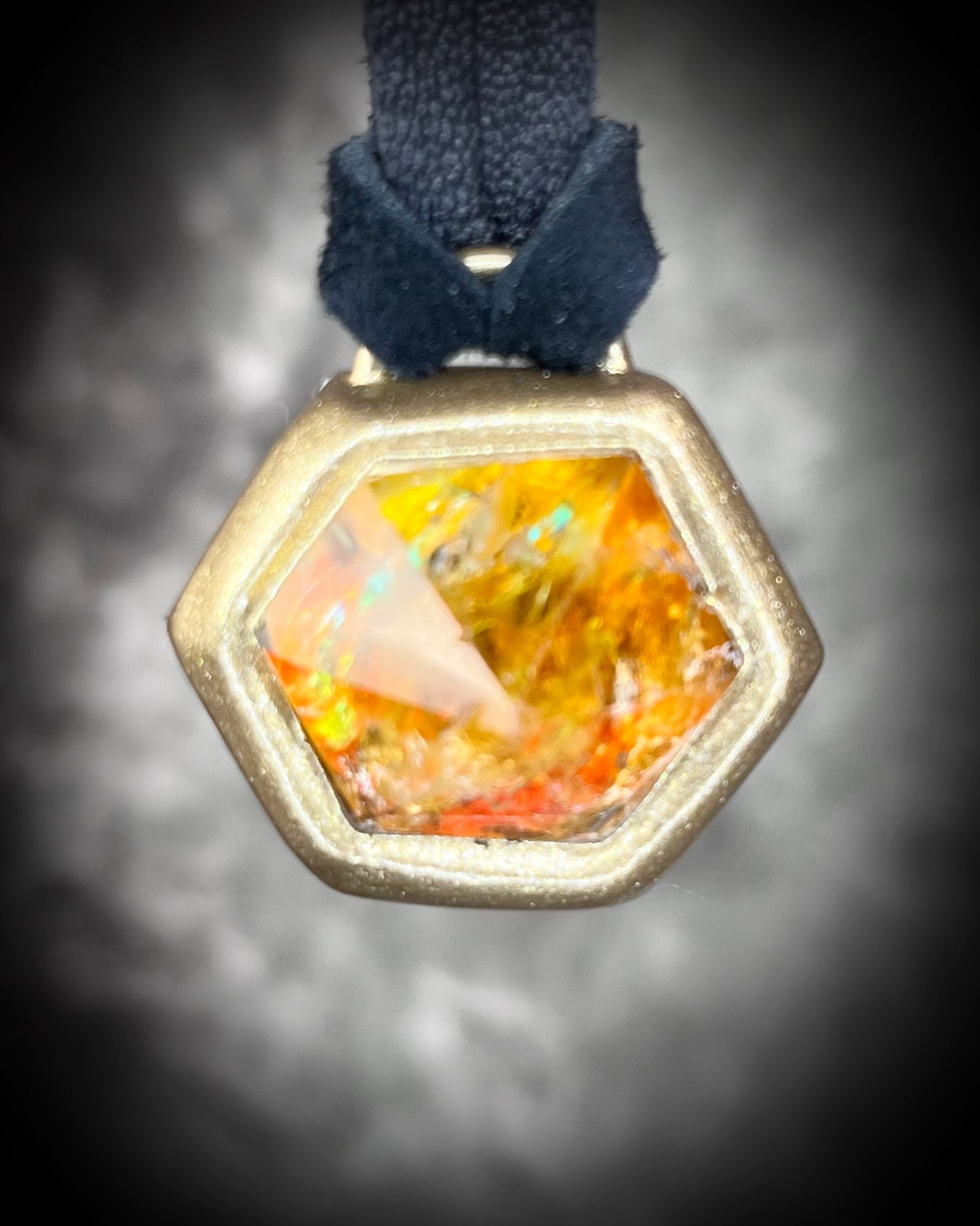 Fiery citrine hexagon crystal pendant with red, green, and orange opalescent flash in gold finish on black leather cord — handcrafted statement talisman