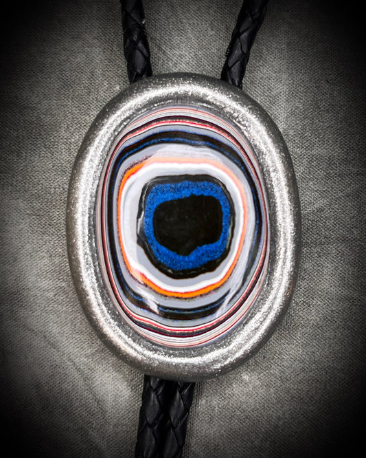 Fordite manmade colorful swirling gemstone Bolo tie set in a gunmetal silver finish and mounted on soft black bolo leather. A talisman for the modern man, crystal jewelry for him. Western 2026 jewelry trend bolo. 