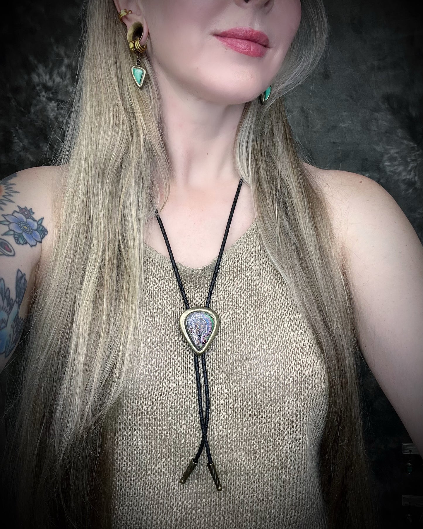Fordite manmade gemstone Bolo tie set in a gold finish and mounted on soft black bolo leather. A talisman for the modern man, crystal jewelry for him. Western 2026 jewelry trend bolo. 