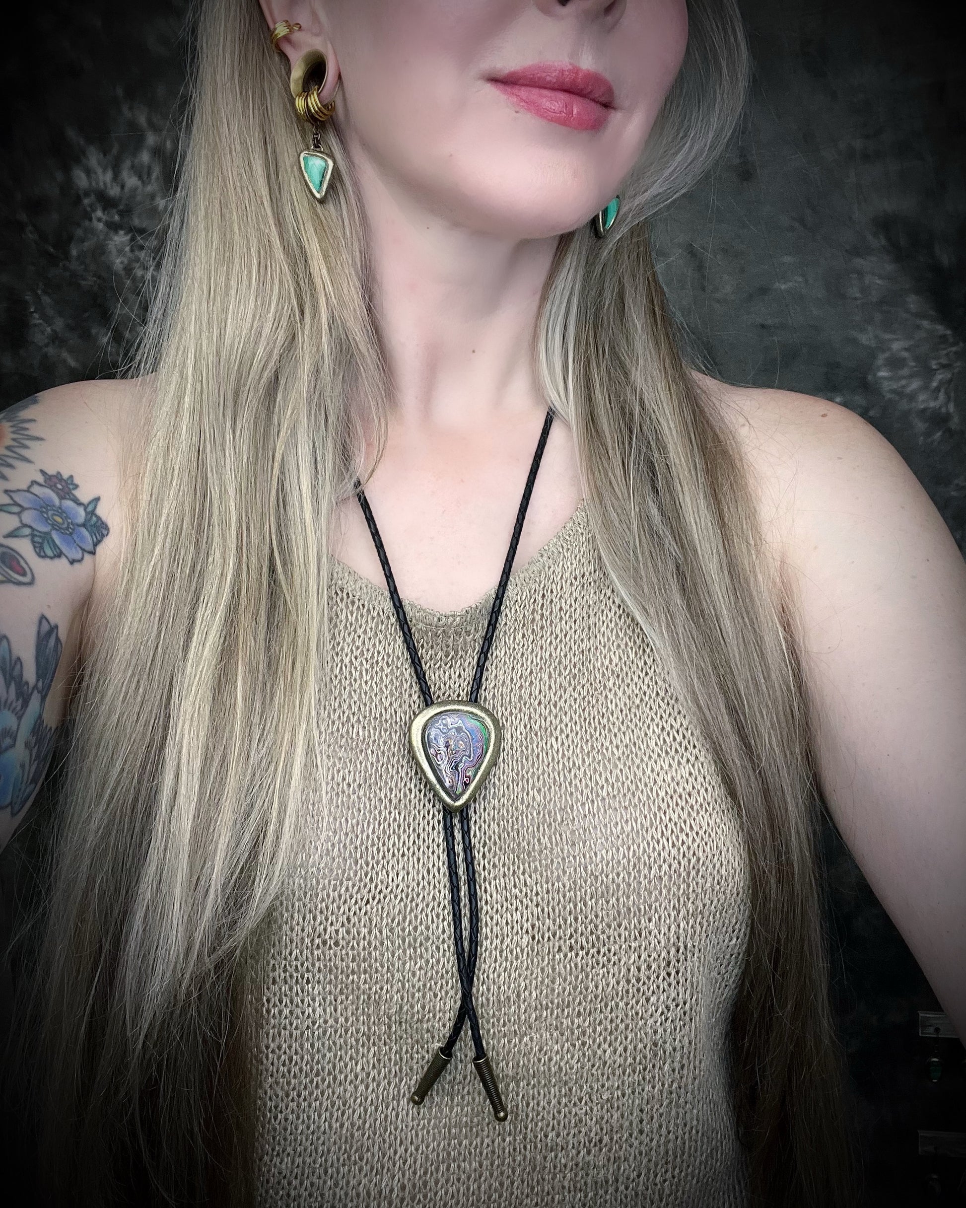 Fordite manmade gemstone Bolo tie set in a gold finish and mounted on soft black bolo leather. A talisman for the modern man, crystal jewelry for him. Western 2026 jewelry trend bolo. 
