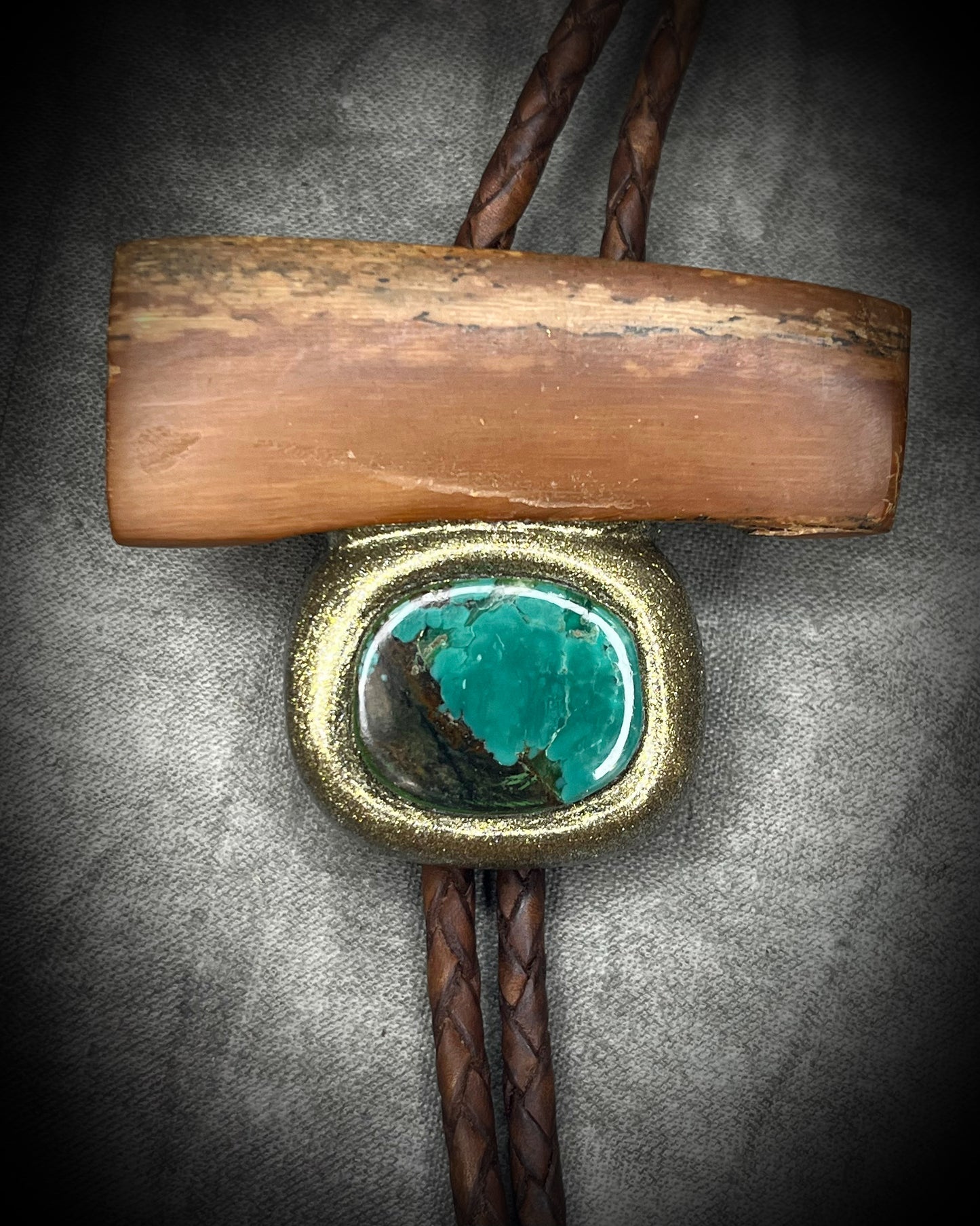 Fossilized mammoth tusk and chrysocolla bolo tie on brown leather with gold finish and gold spike tips, handmade by Become Spellbound.
