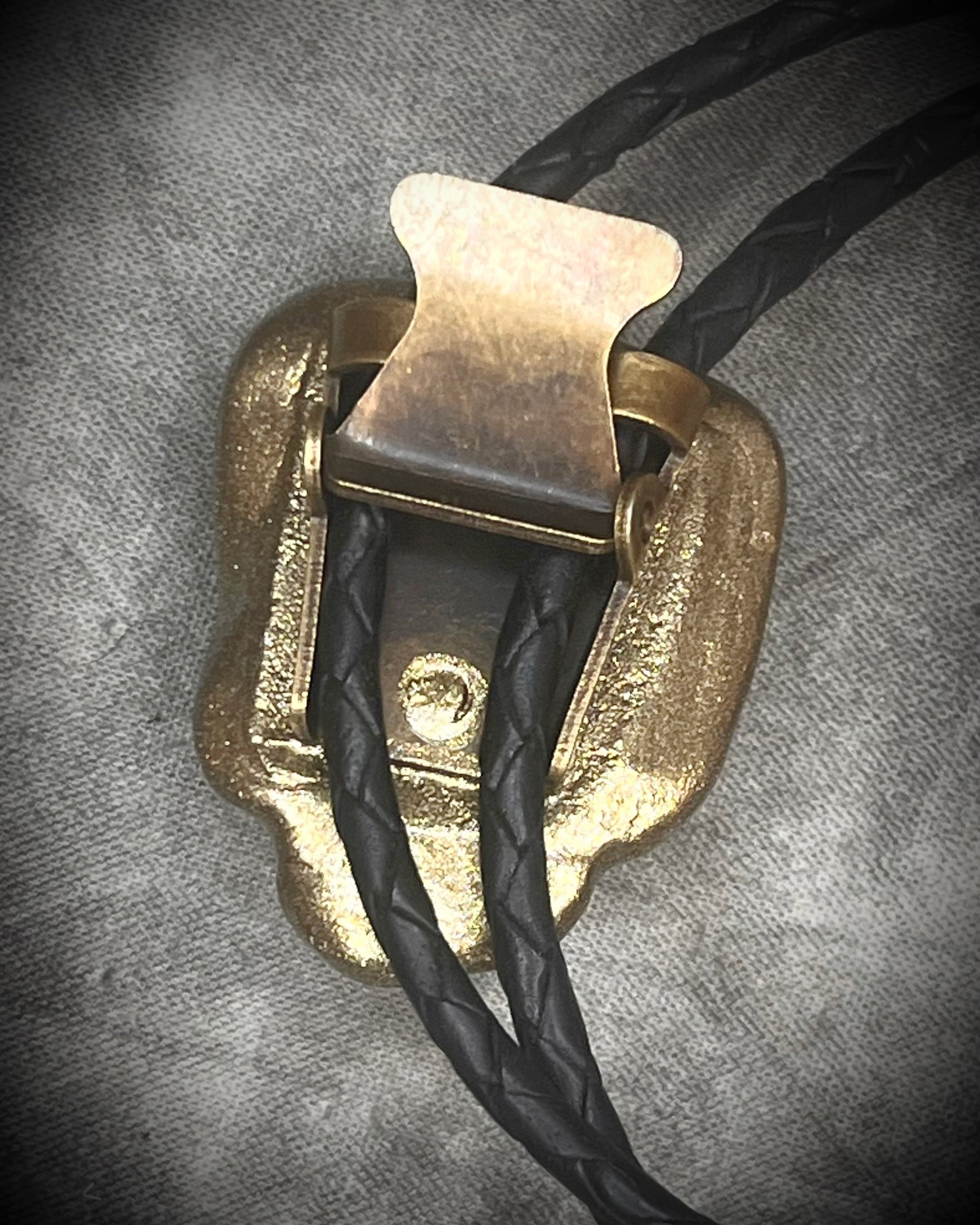 Gemmy Dioptase crystal bolo tie in deep green hues framed in a gold finish and strung on black bolo tie leather with gold tone brass spike tips. Gemstone bolo tie western inspired jewelry for him. Handmade in Baltimore, Maryland.