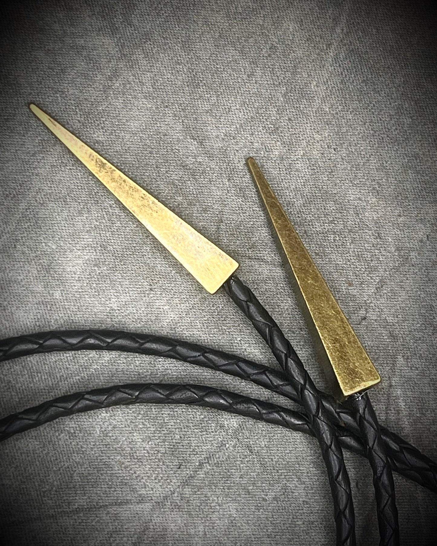 Gemmy Dioptase crystal bolo tie in deep green hues framed in a gold finish and strung on black bolo tie leather with gold tone brass spike tips. Gemstone bolo tie western inspired jewelry for him. Handmade in Baltimore, Maryland.