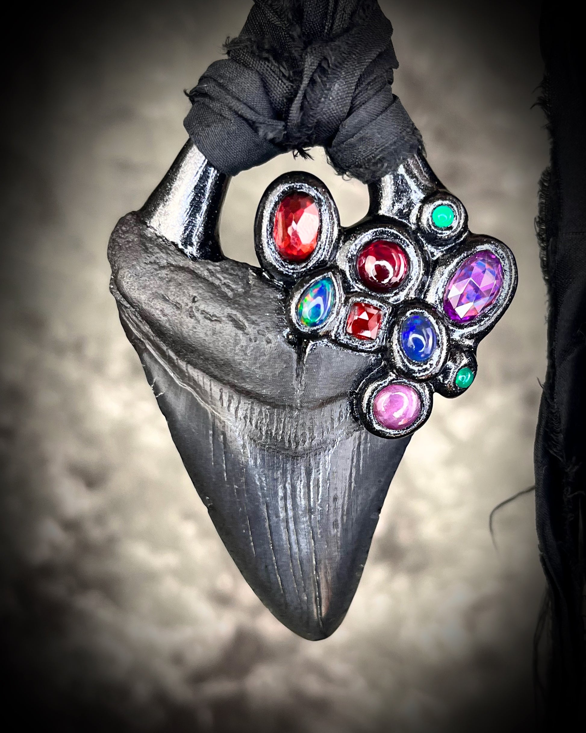 Dark Queen inspired handmade gemstone encrusted megalodon fossil tooth necklace.  This talisman serves to ground and protect and would be at home on a fantasy film set or a birthday cosplay costume!  Made in the USA on recycled silk for eco-friendly dark luxury. 