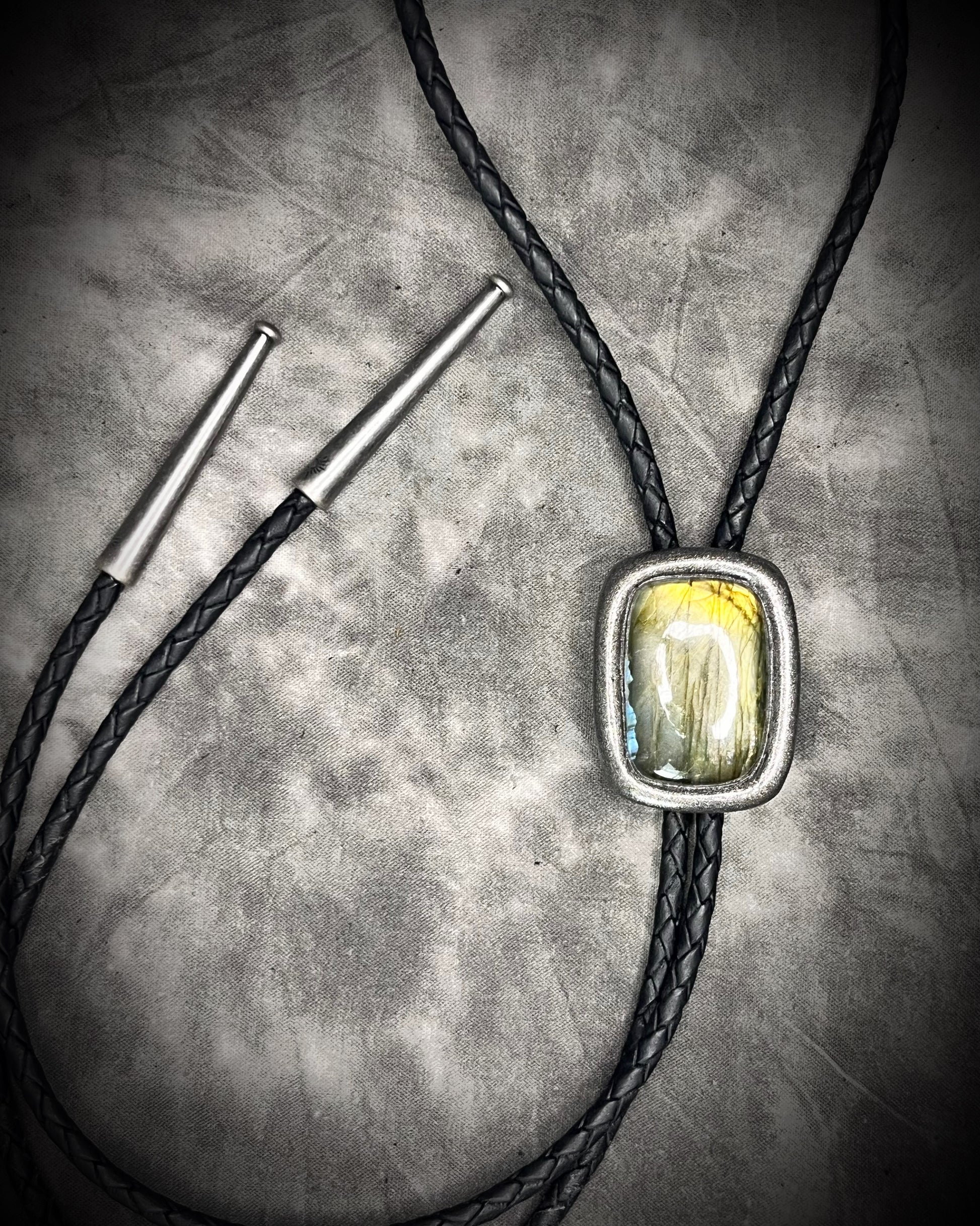 Bolo tie with a stone pendant on a textured surface